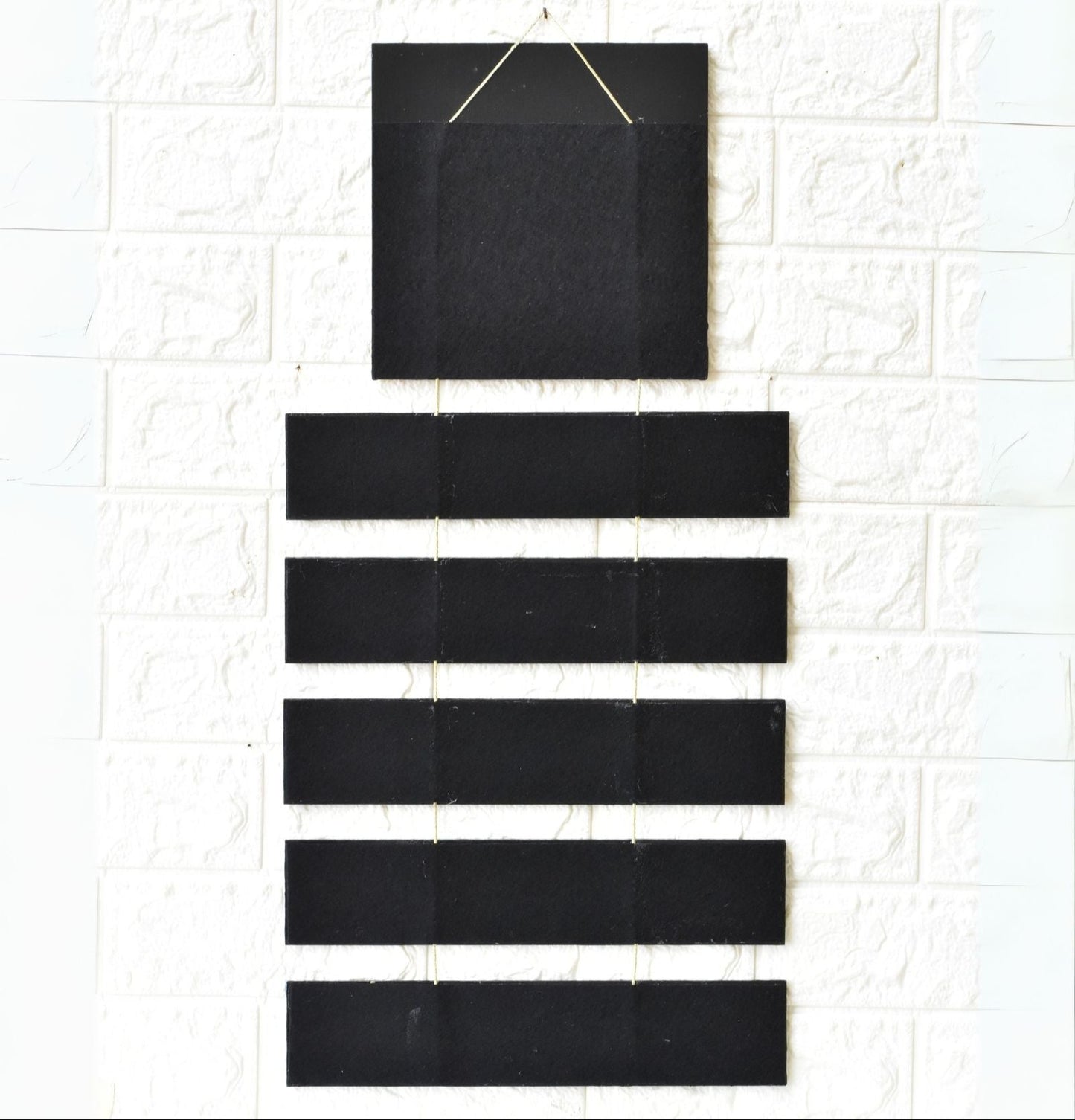 Set of black square and rectangular tiles on a textured white surface