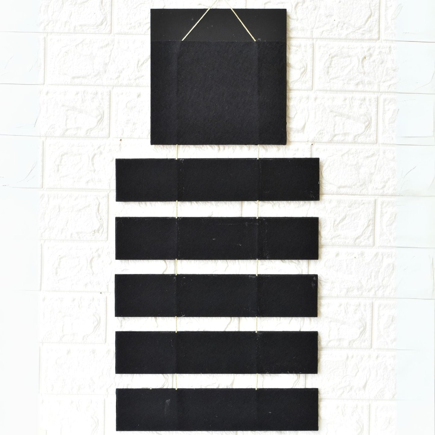 Set of black rectangular tiles on a textured white surface