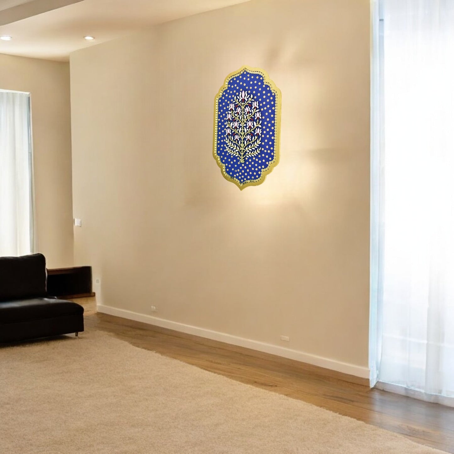 Decorative wall art on a beige wall in a room with a black sofa and white curtains.