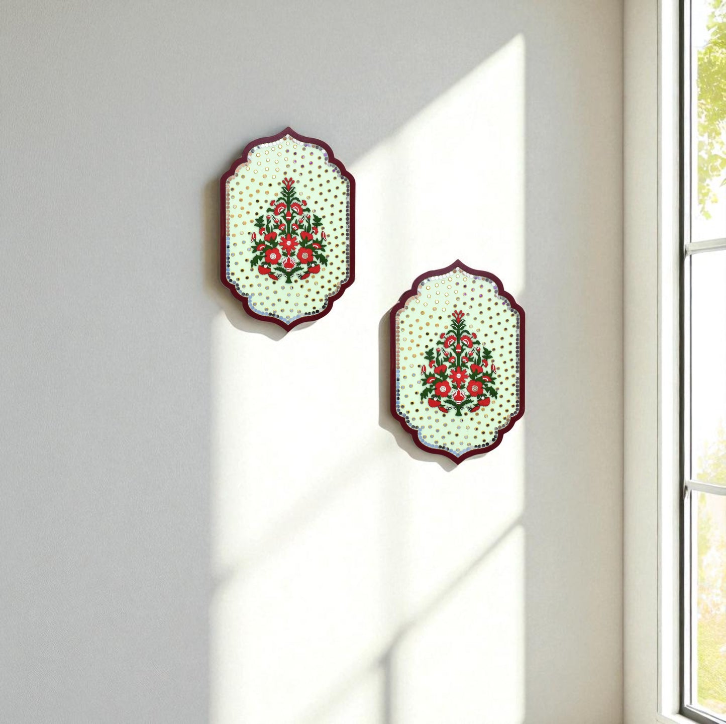 Two decorative wall hangings with floral patterns on a light gray wall.