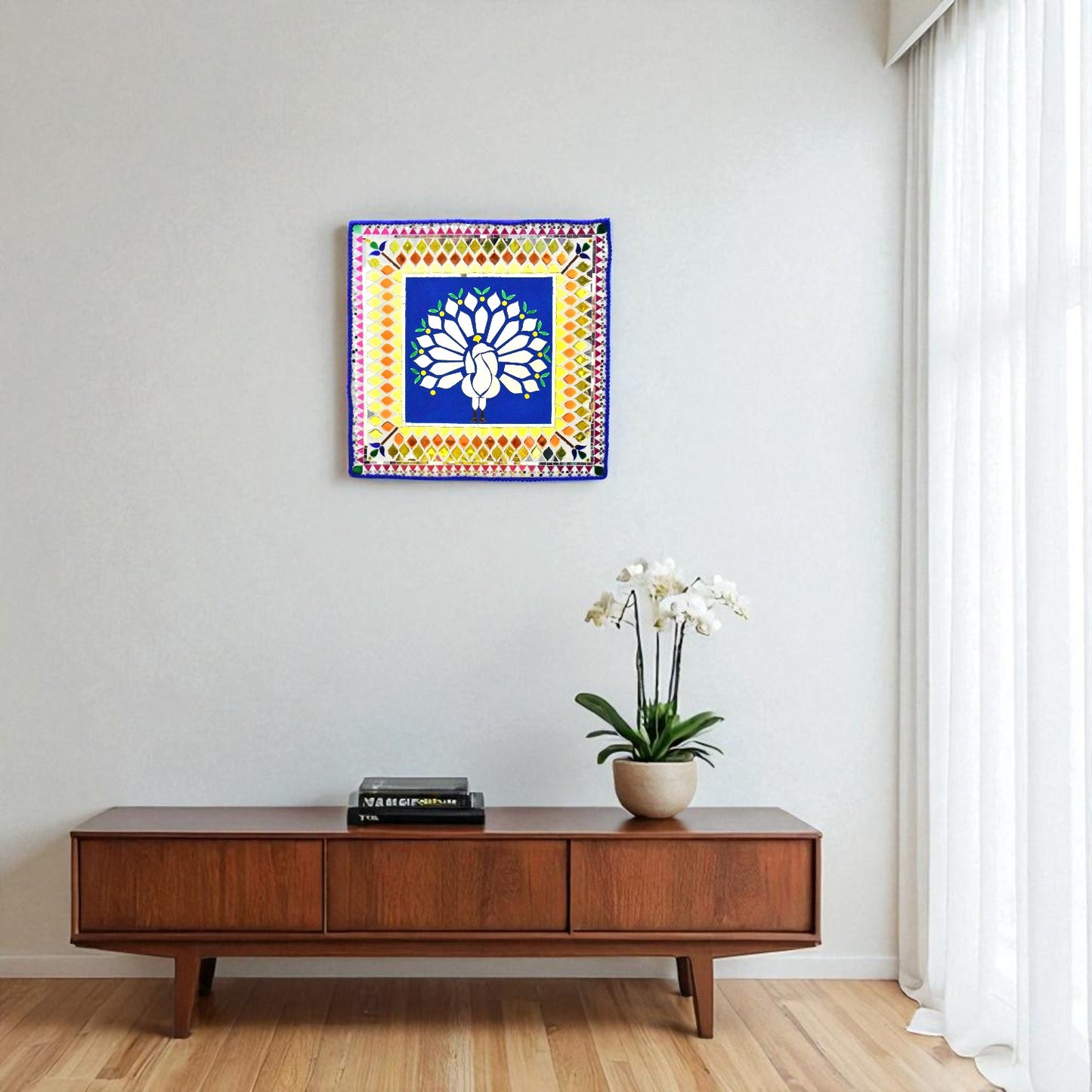 Decorative wall art above a wooden console table with a plant and books.