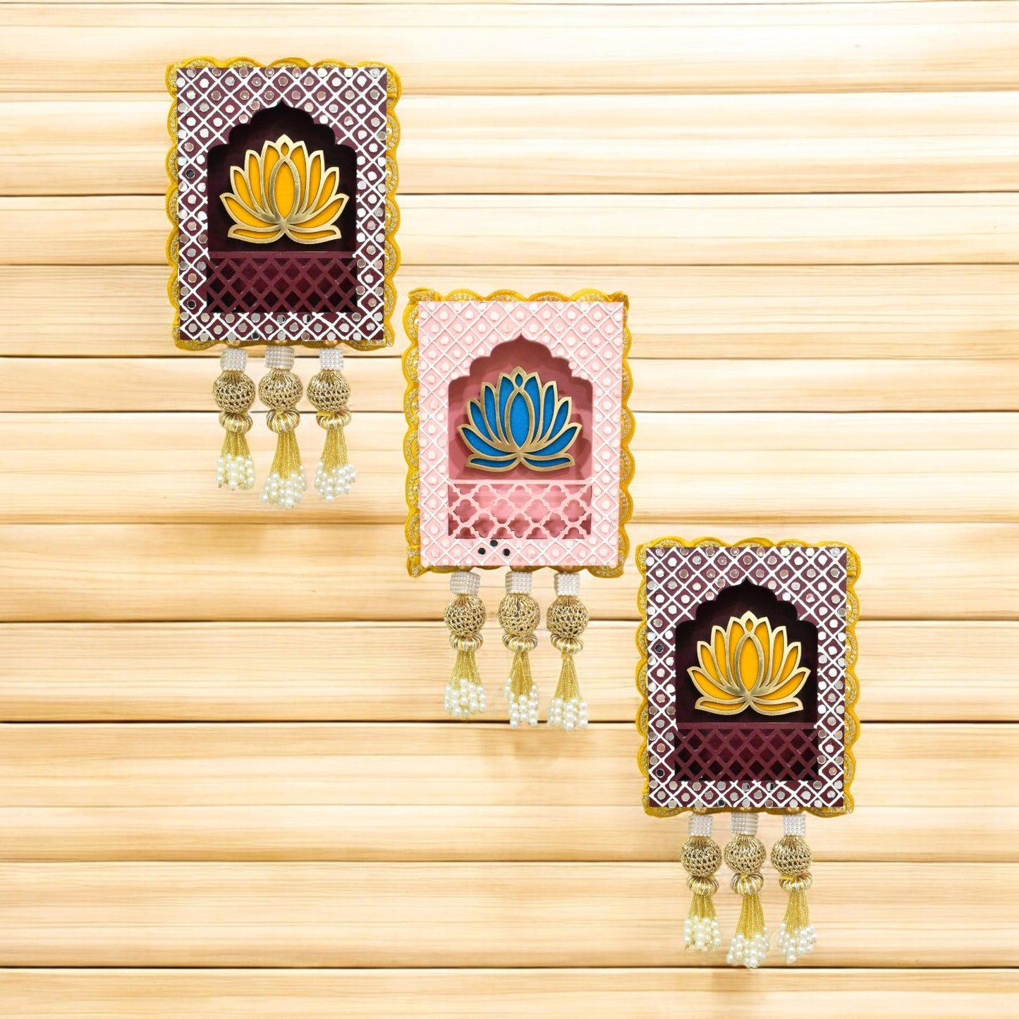 Three rectangular Indian jharokha wall hangings with lotus motifs, decorative patterns, and tassels, displayed against a light background.