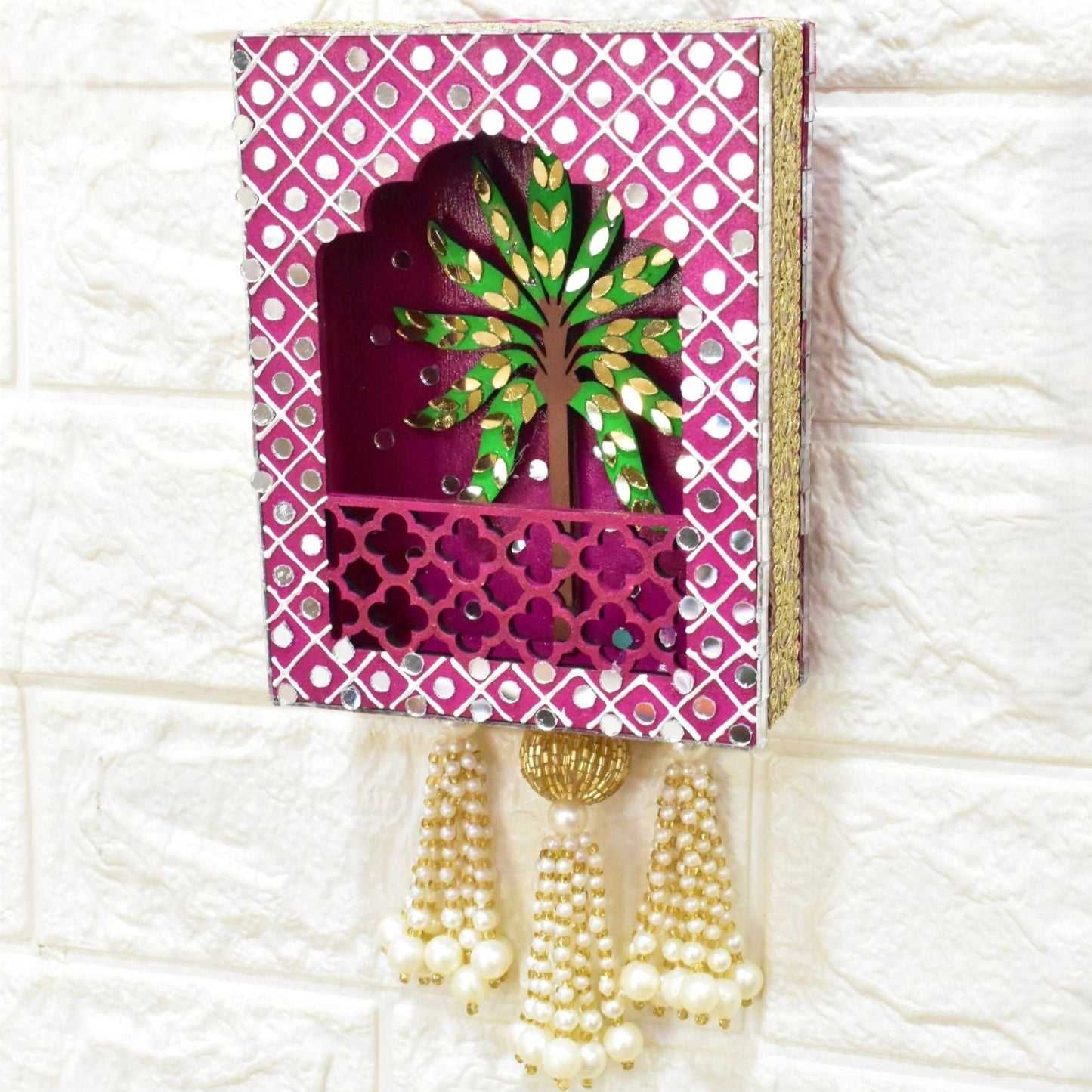 Decorative wall hanging with a tree design on a pink background, featuring tassels.