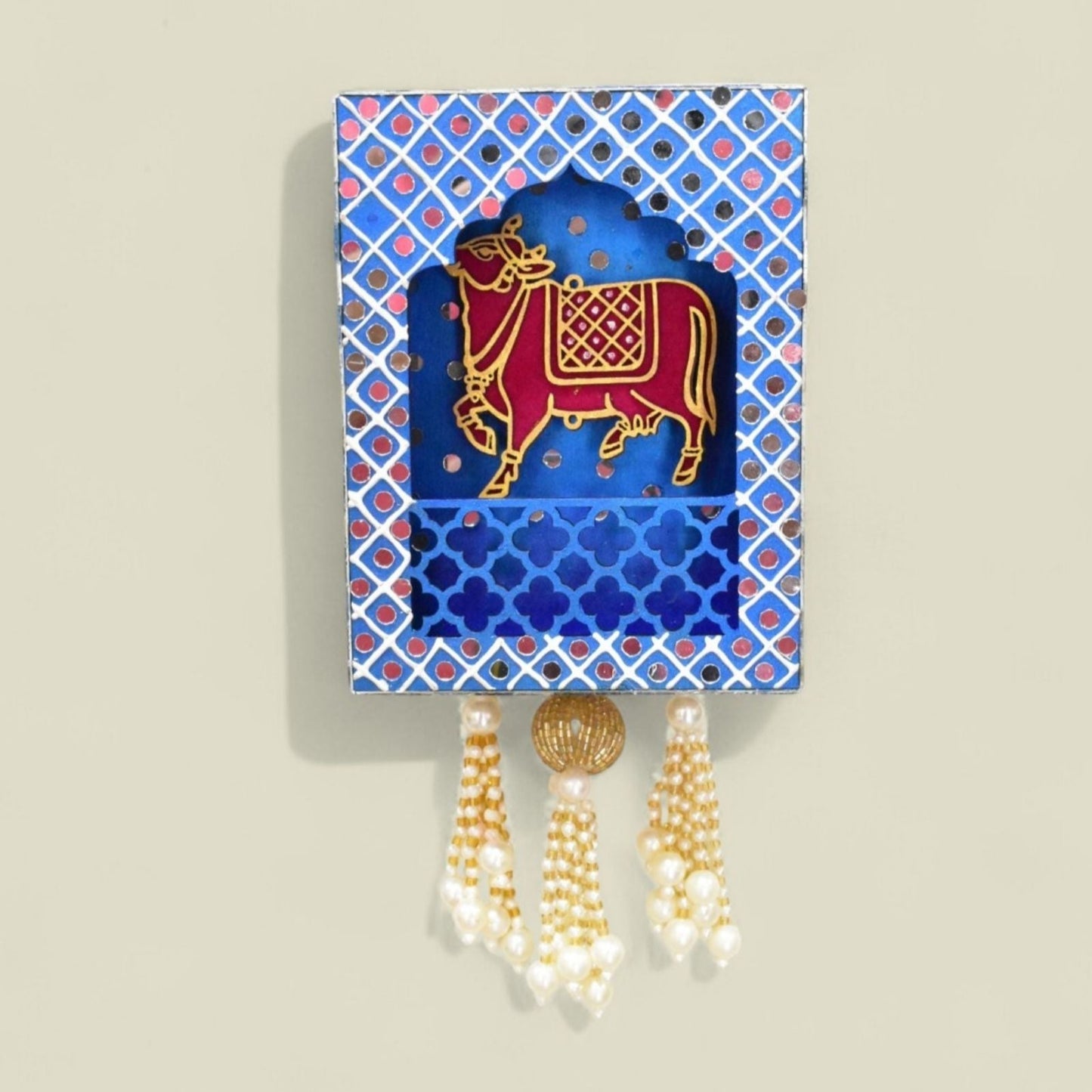 Decorative wall shelf with a cow illustration on a blue and pink patterned background.