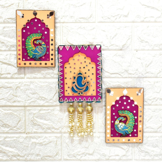 Decorative wall hangings with peacock designs on a textured white wall.