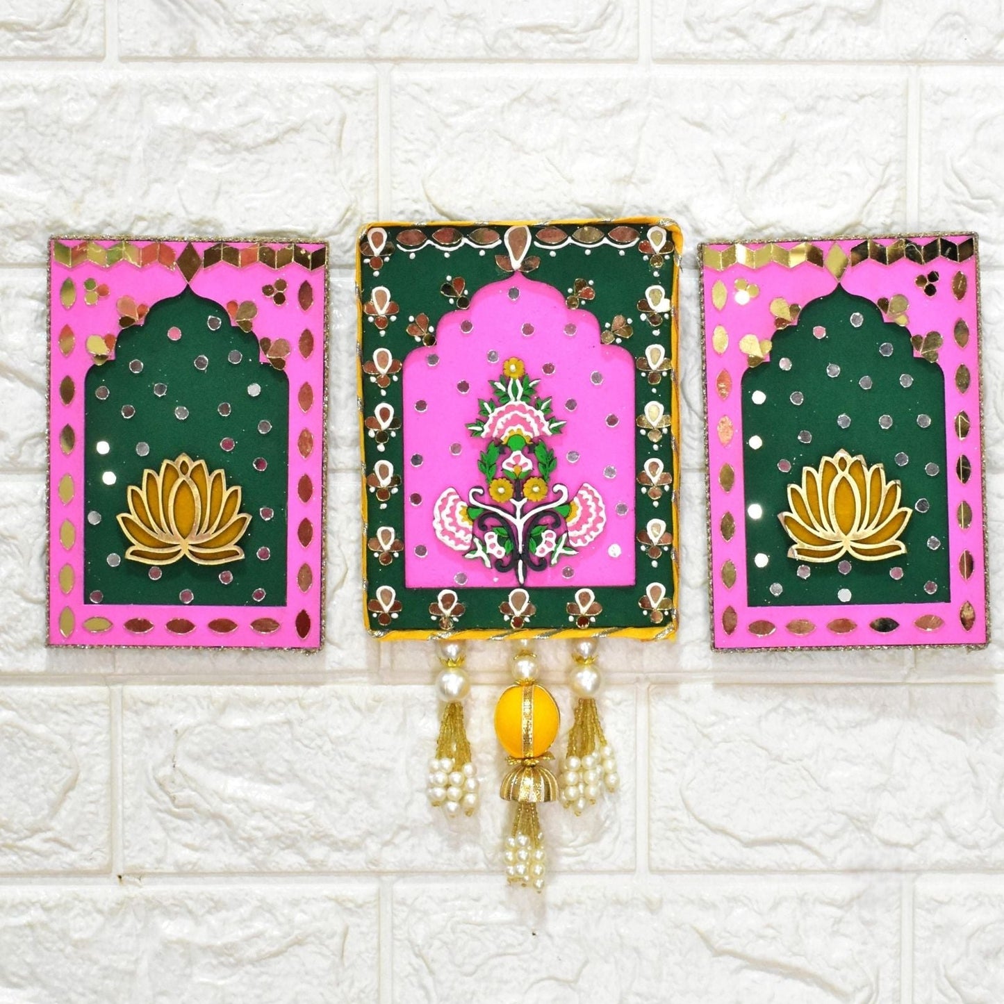 Decorative wall hanging with pink and green panels featuring floral designs on a white tiled background.