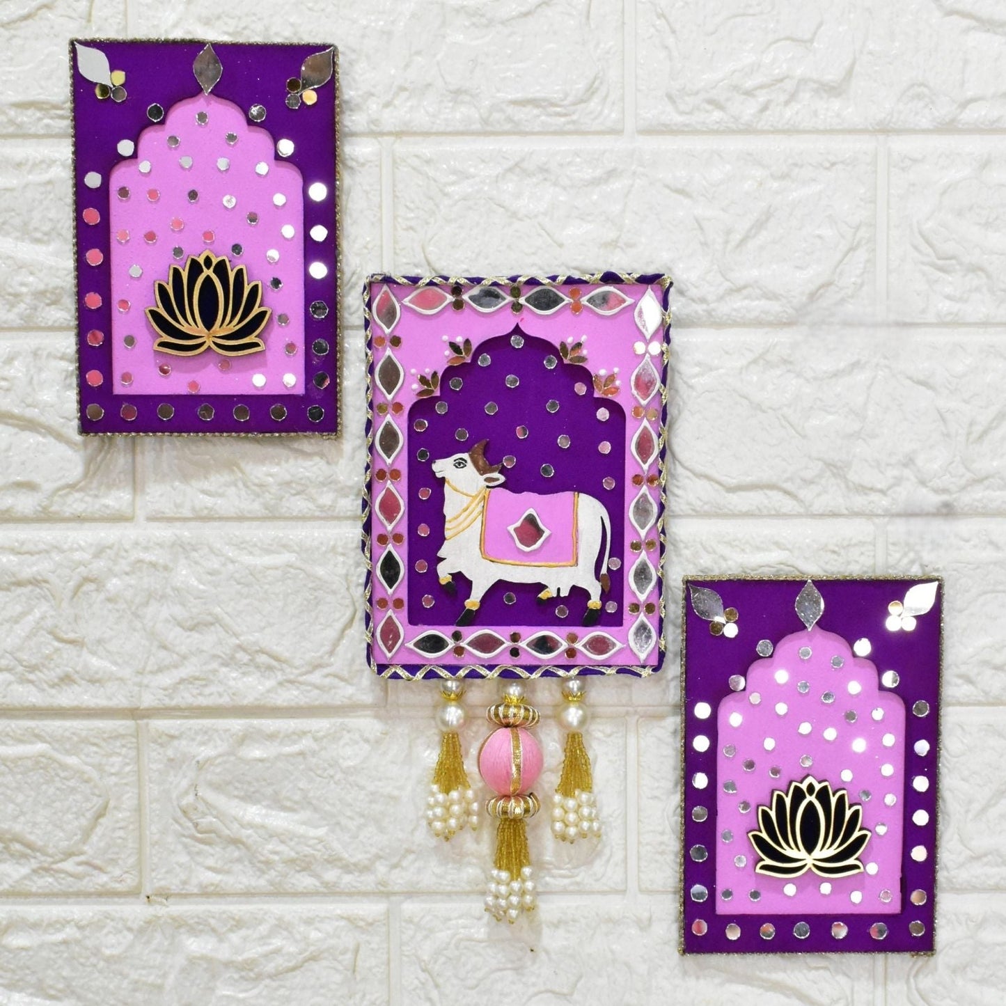 Decorative wall hangings with purple and pink designs on a textured white wall.
