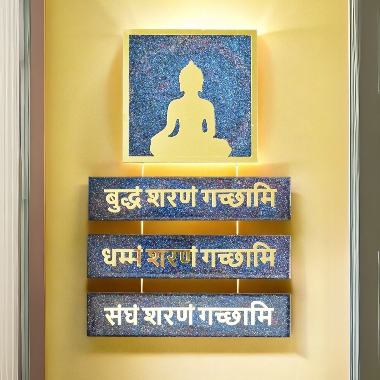 Decorative wall art with Buddha silhouette and Sanskrit text on a yellow wall.