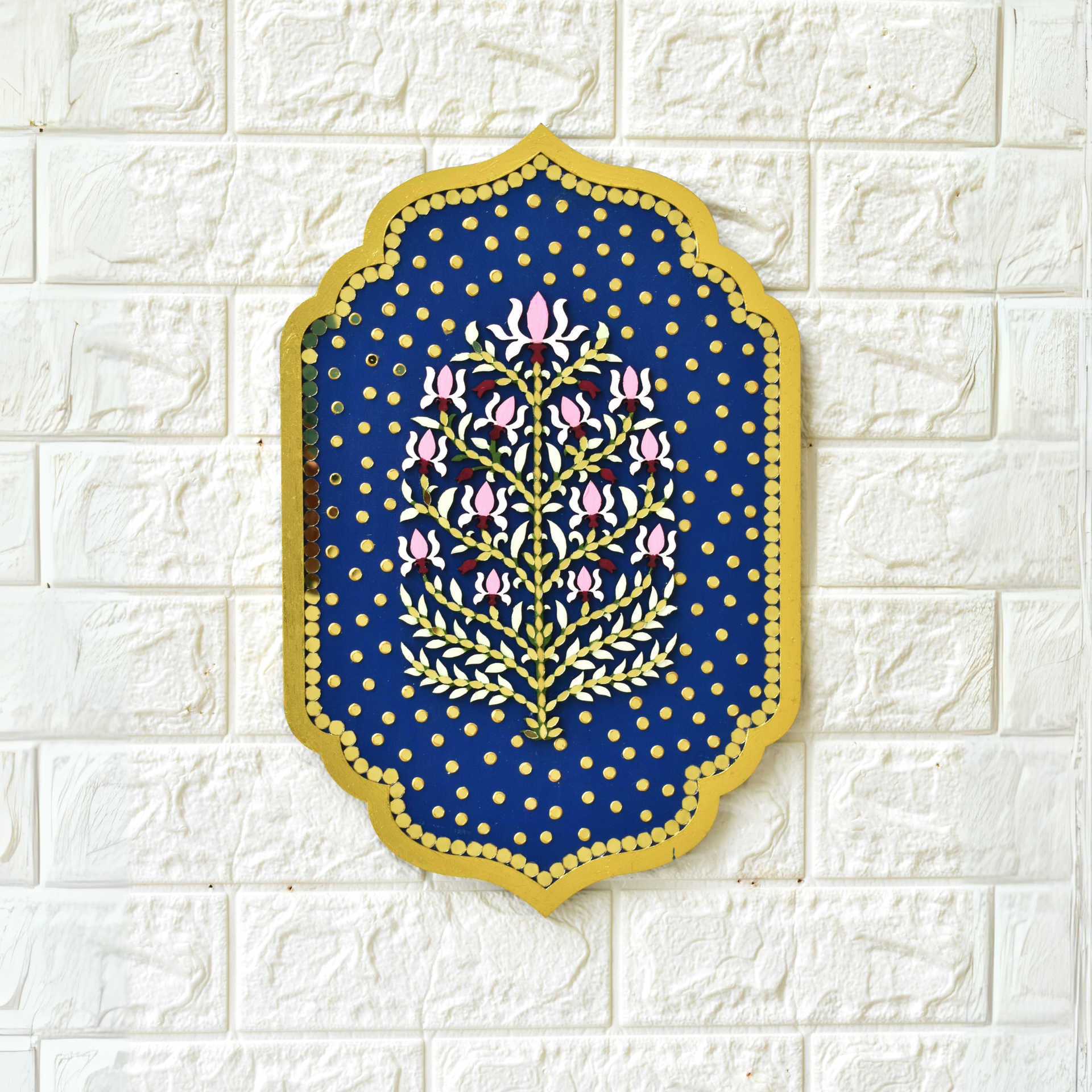 Decorative wall art with floral design on a blue background, mounted on a white textured wall.