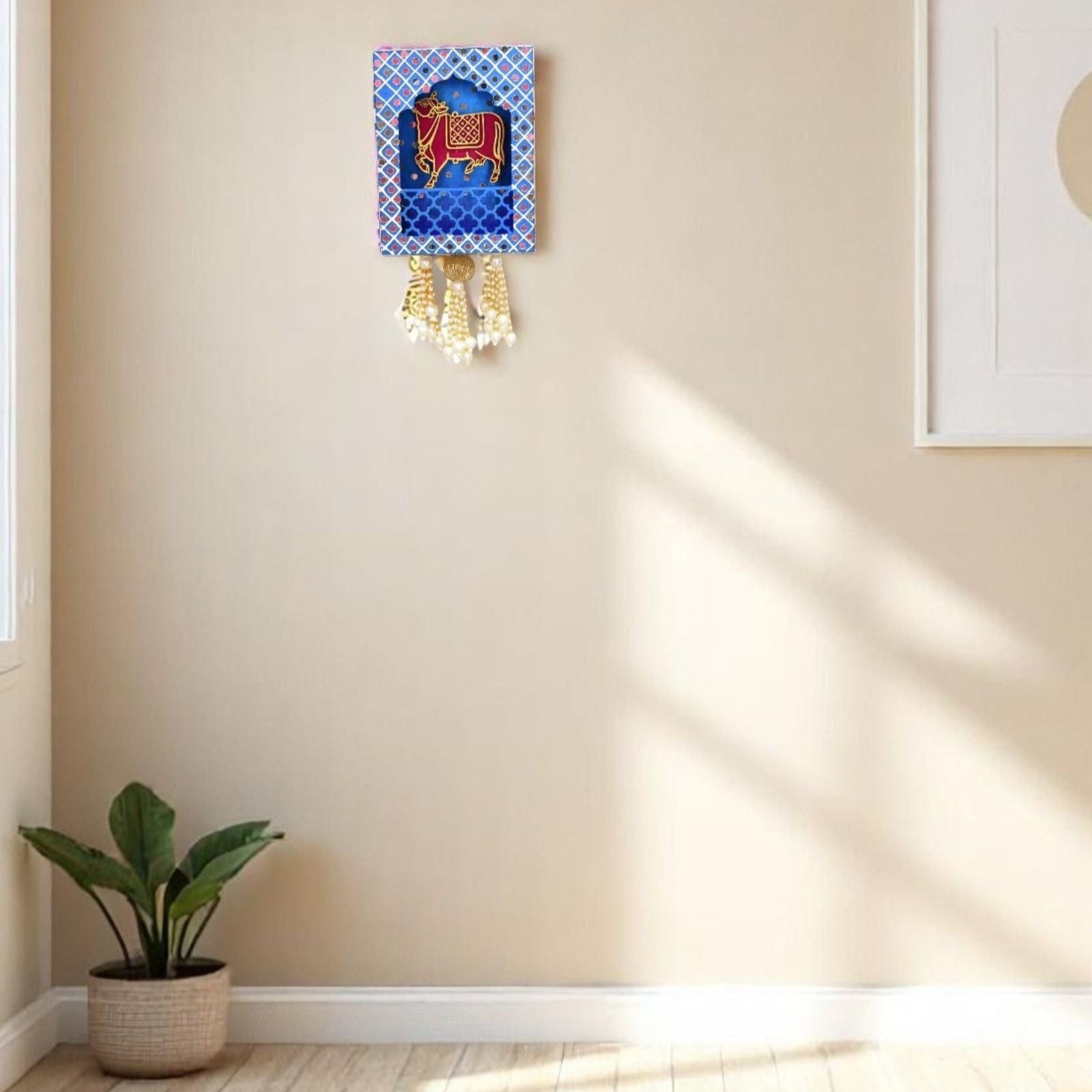 Decorative wall hanging with a blue and gold design on a beige wall.