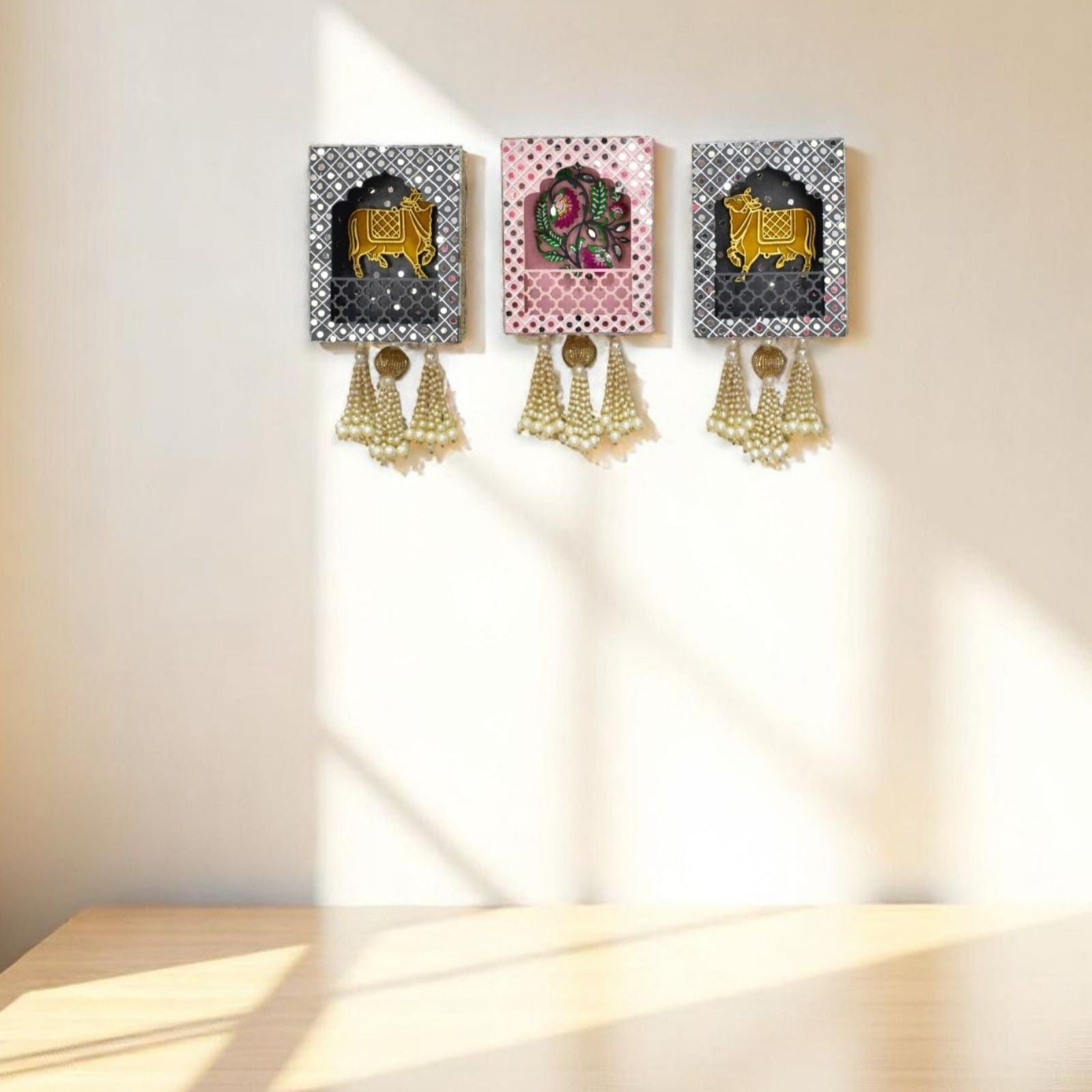 Three decorative wall hangings with tassels on a light-colored wall.
