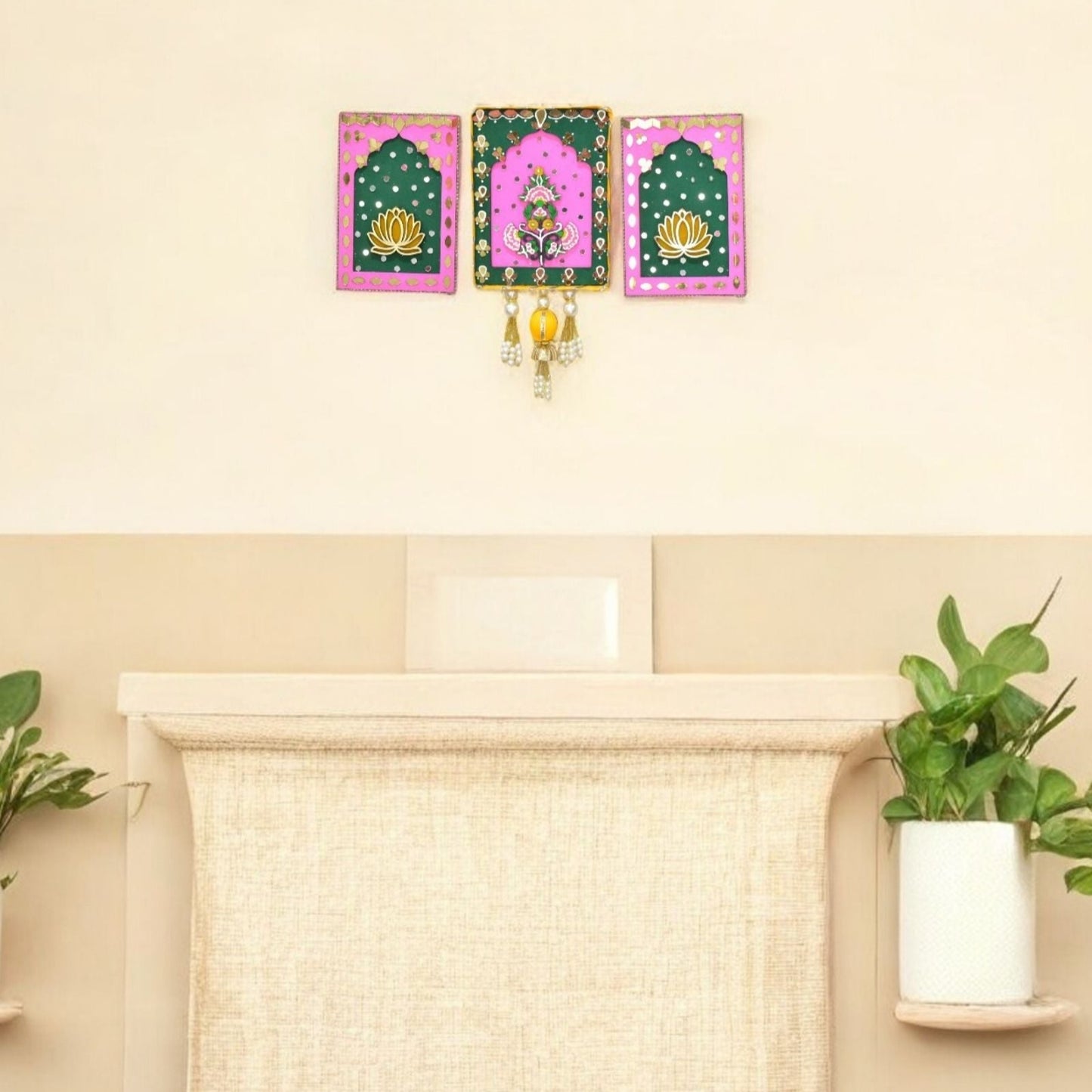 Decorative wall art with pink and green frames on a beige wall above a fireplace.