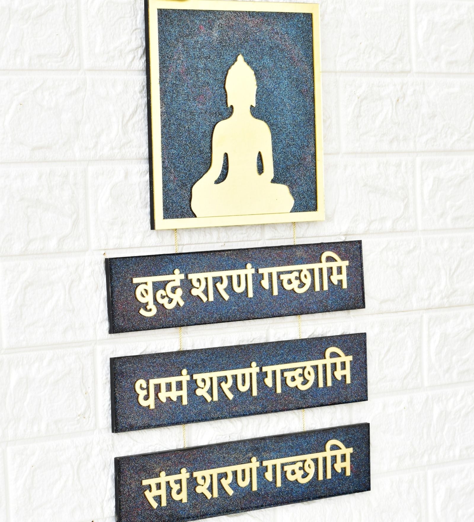 Decorative wall art with Buddha silhouette and Sanskrit text on a textured white background