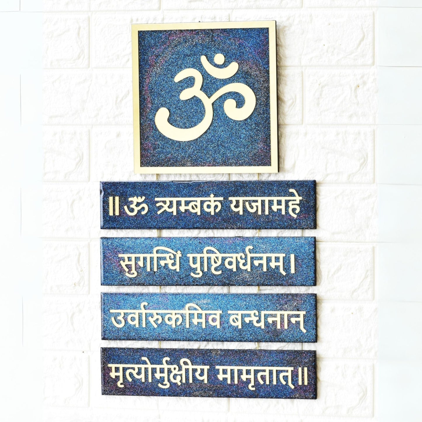 Decorative wall art with Om symbol and Sanskrit text on a white background