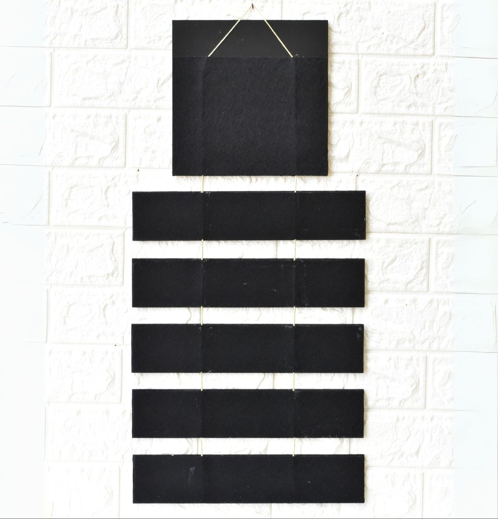 Set of black square and rectangular tiles on a textured white surface