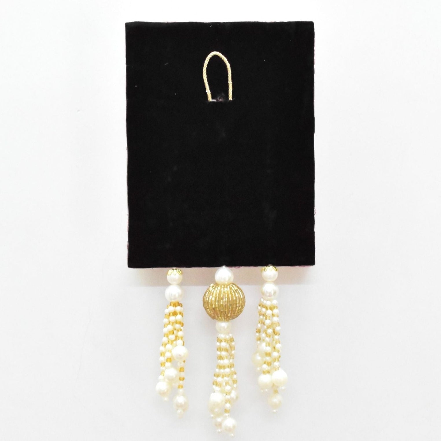 Pair of pearl and gold beaded hangings on a black card against a white background