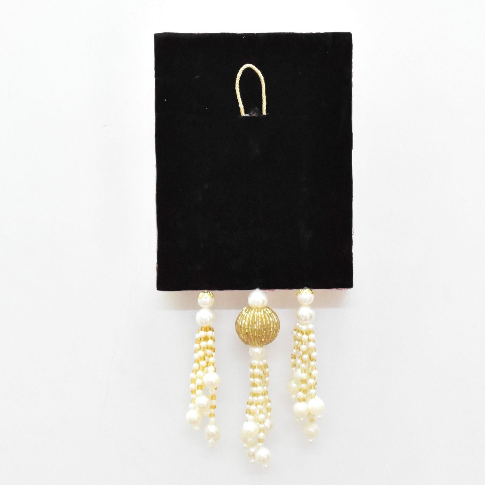 Pair of pearl and gold latkan on a black card against a white background
