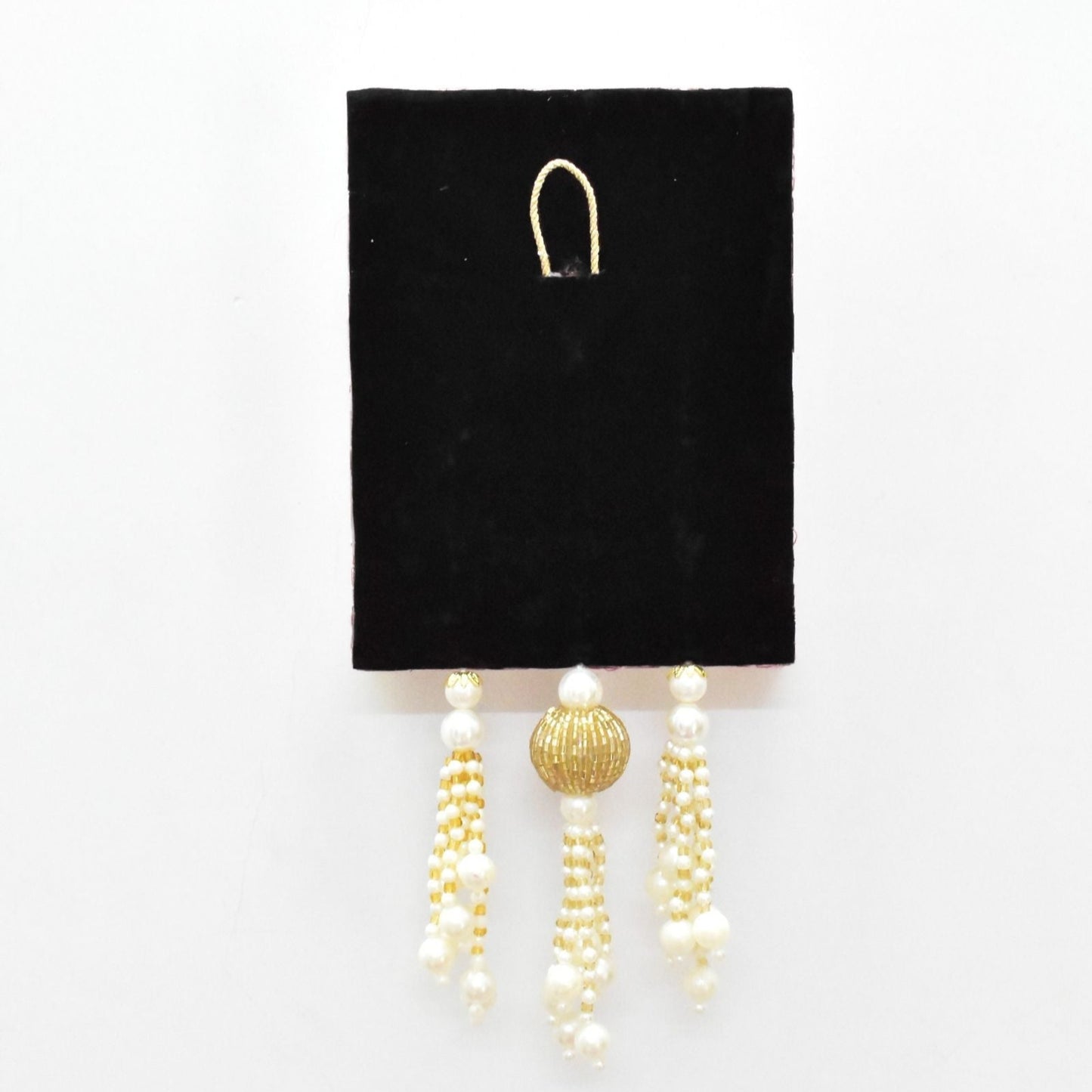 Pair of pearl and gold beaded earrings on a black card against a white background