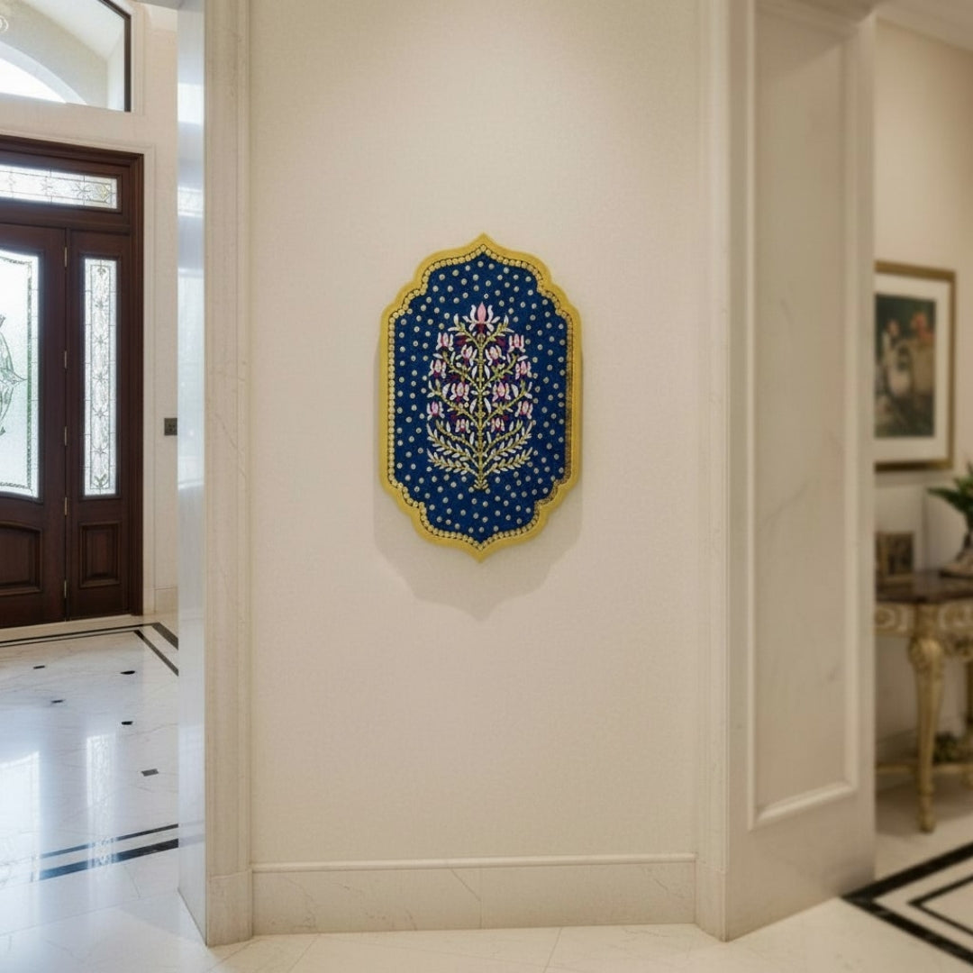 Handcrafted blue floral wall art with gold mirrors on a cream wall in a home interior.