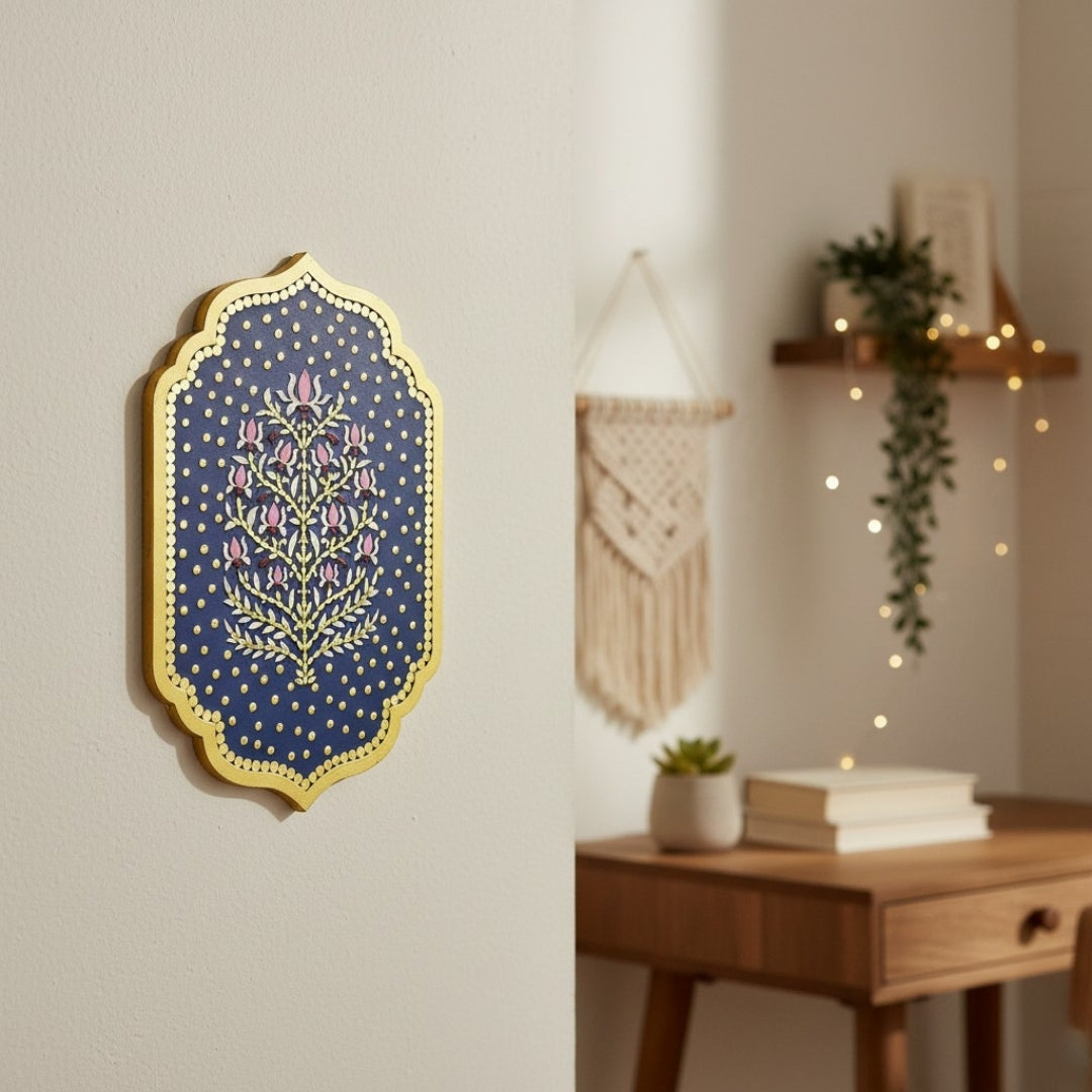 Indian ethnic blue wall art piece with lotus floral pattern and mirrors on a wall with a wooden shelf and plants in the background.