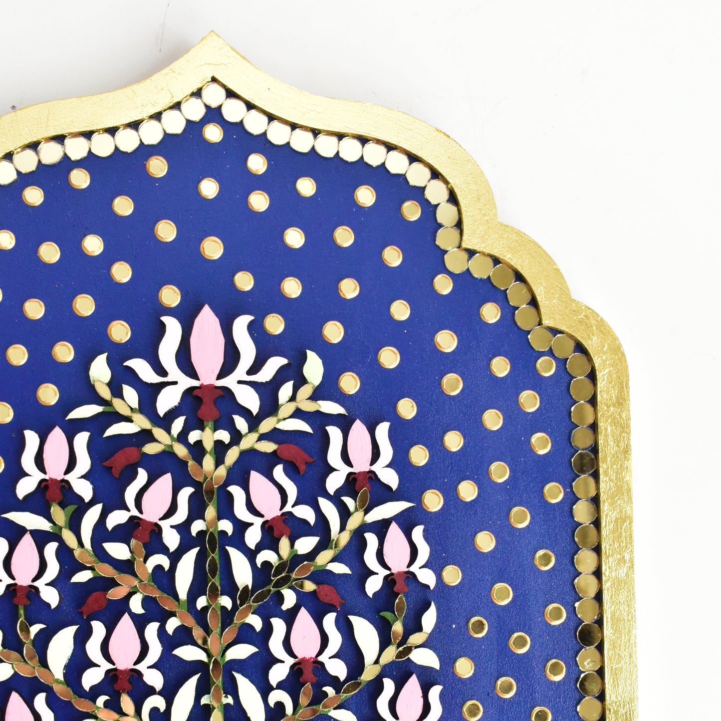 Close up of floral wall art with mirrors and lotus floral design and gold accents on a white background.