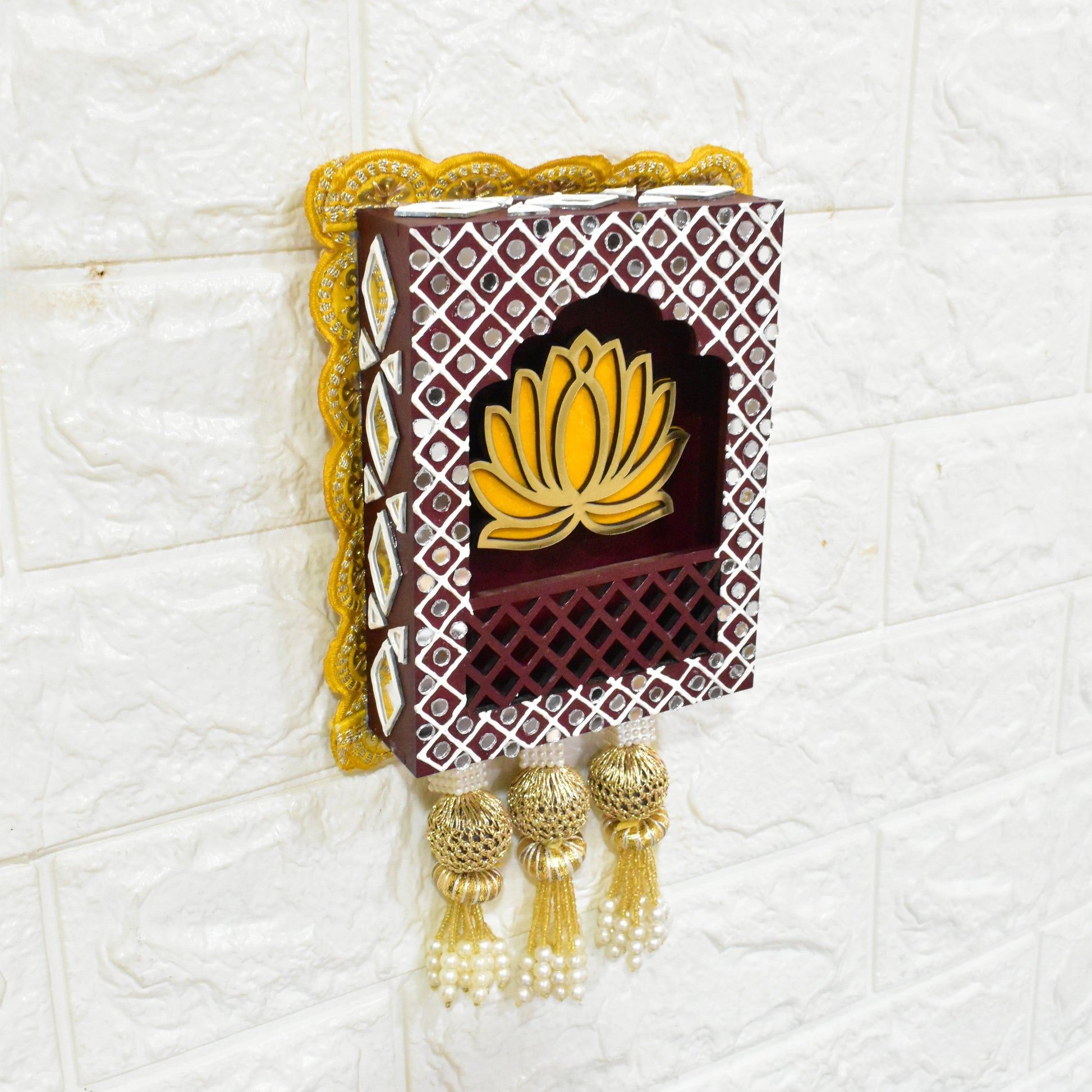 Jharokha wall hangings featuring a lotus flower design, in yellow and brown and gold colors, with pearl tassels.