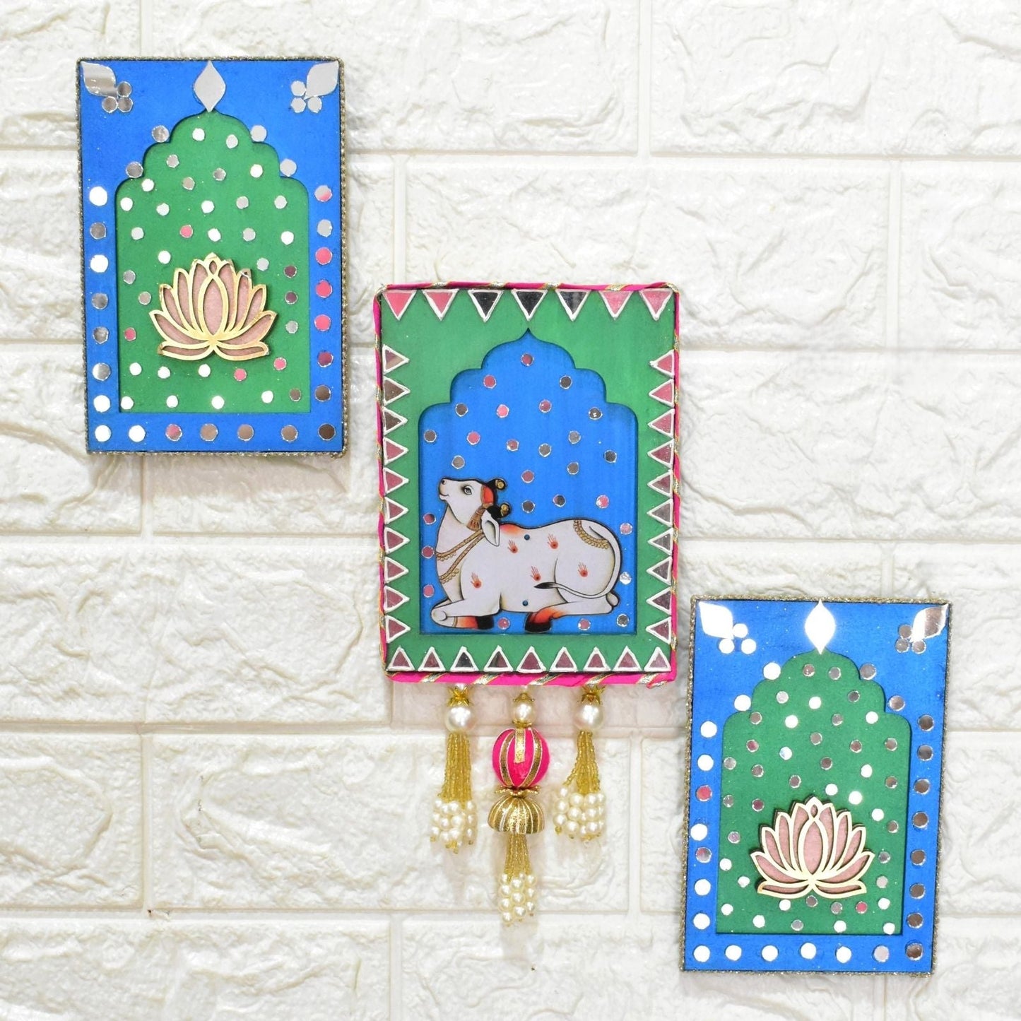 Blue & Green Decorative wall hangings jharokha with lotus and cow designs in on a textured white background.