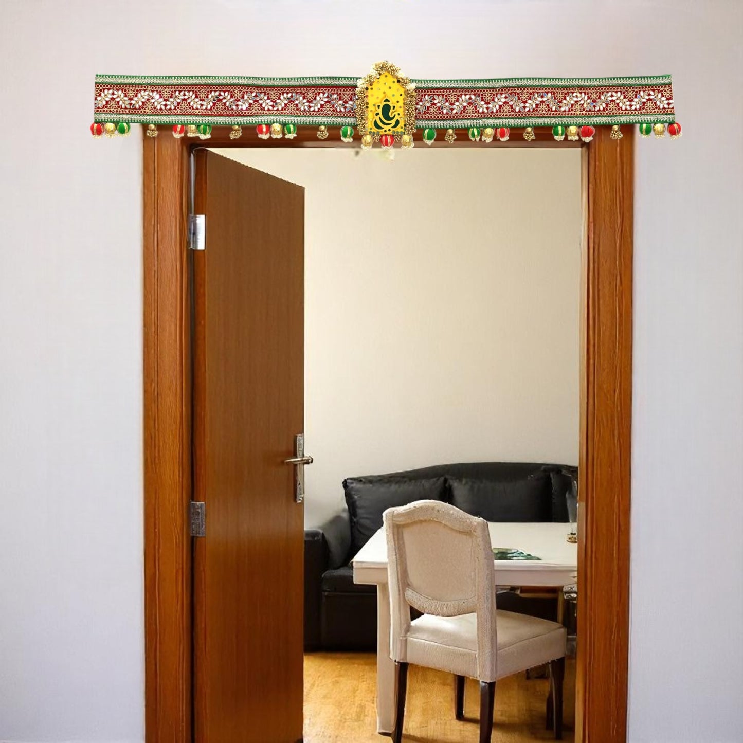 Decorative door hanging toran on wall with lights above a room with a table and chairs.