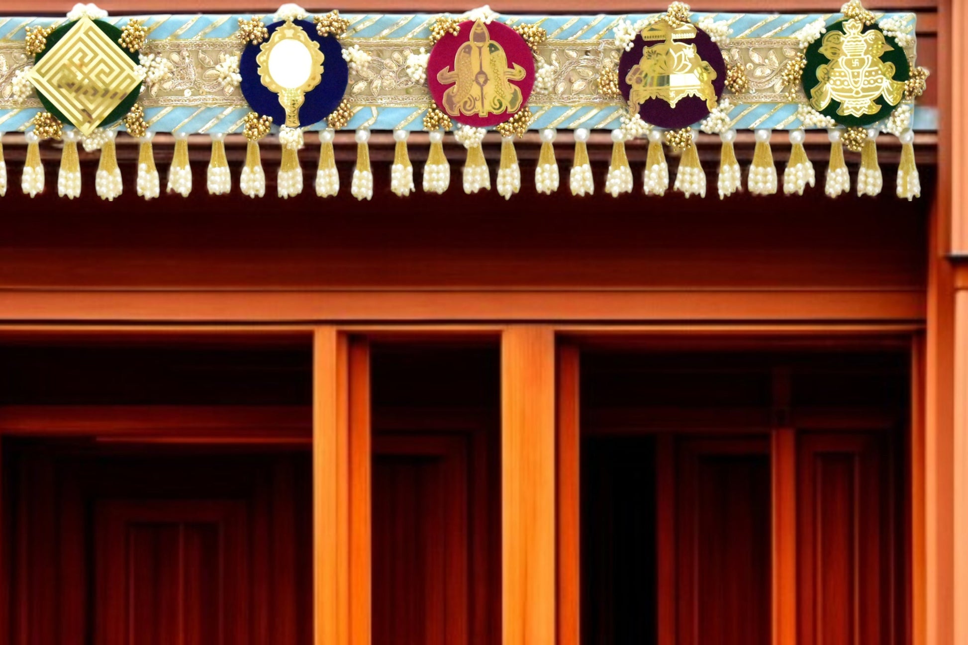 Decorative Toran door hanging above a doorway made with a theme of ashtamangal jain symbols