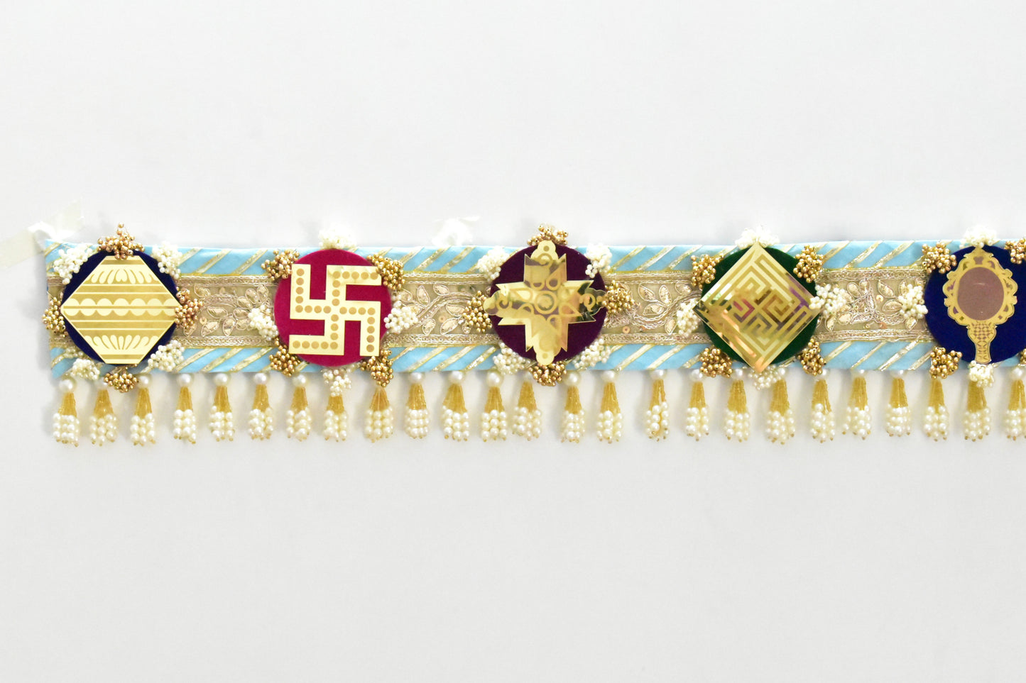 Decorative Toran door hanging above a doorway made with a theme of ashtamangal jain symbols