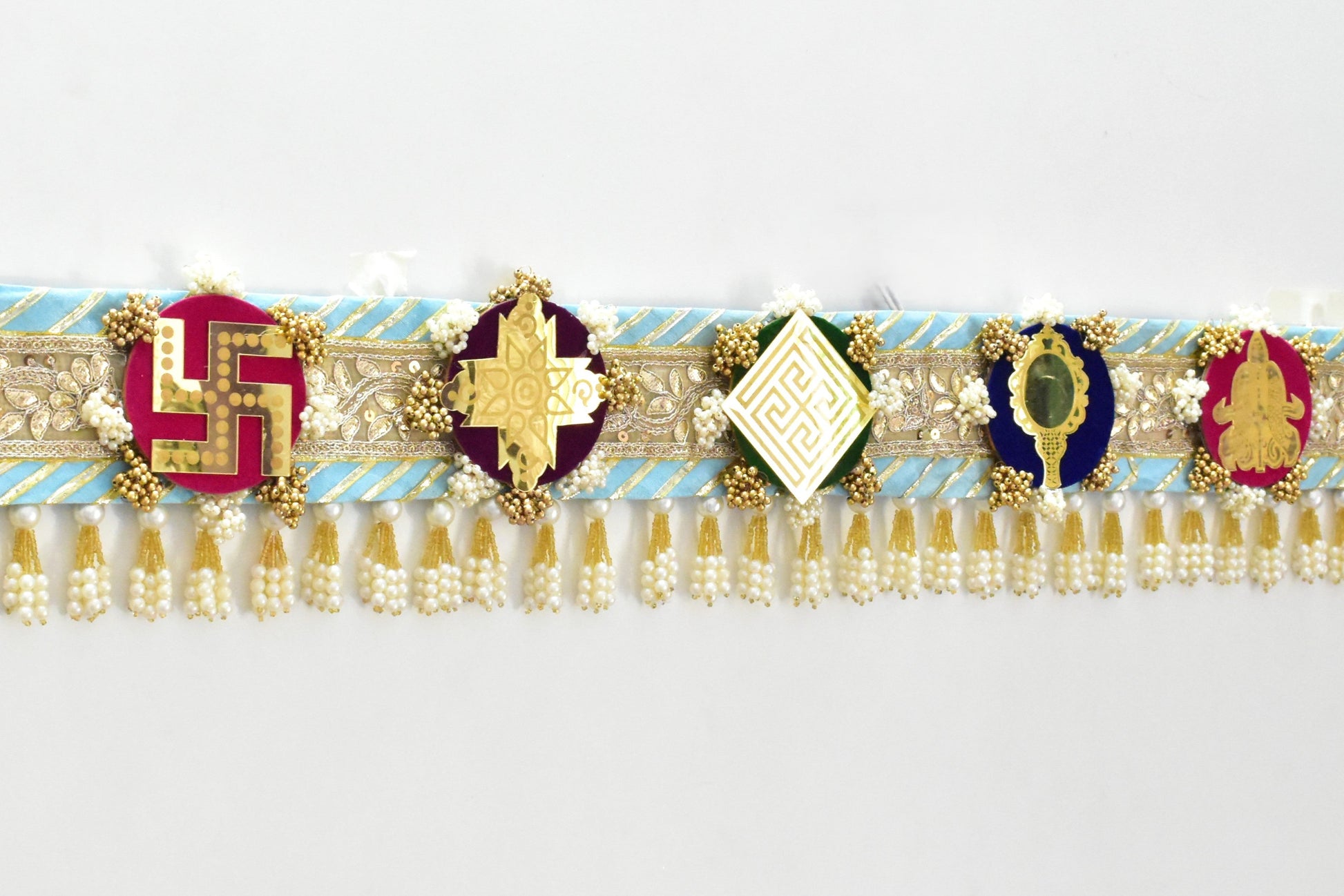 Decorative Toran door hanging above a doorway made with a theme of ashtamangal jain symbols