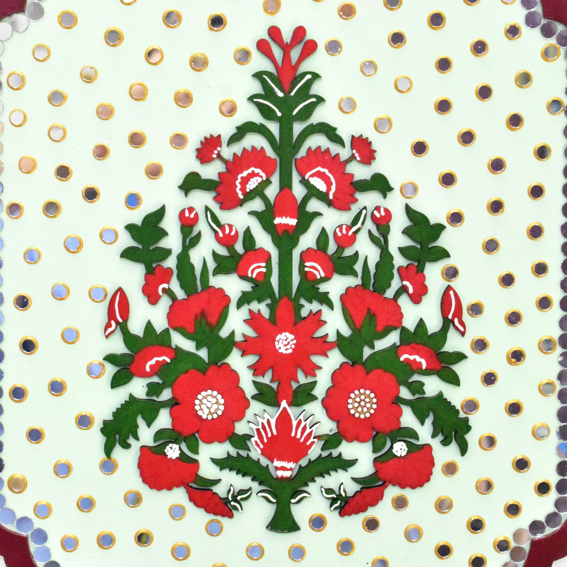 Decorative design with red flowers and green leaves on a white background with gold polka dots.