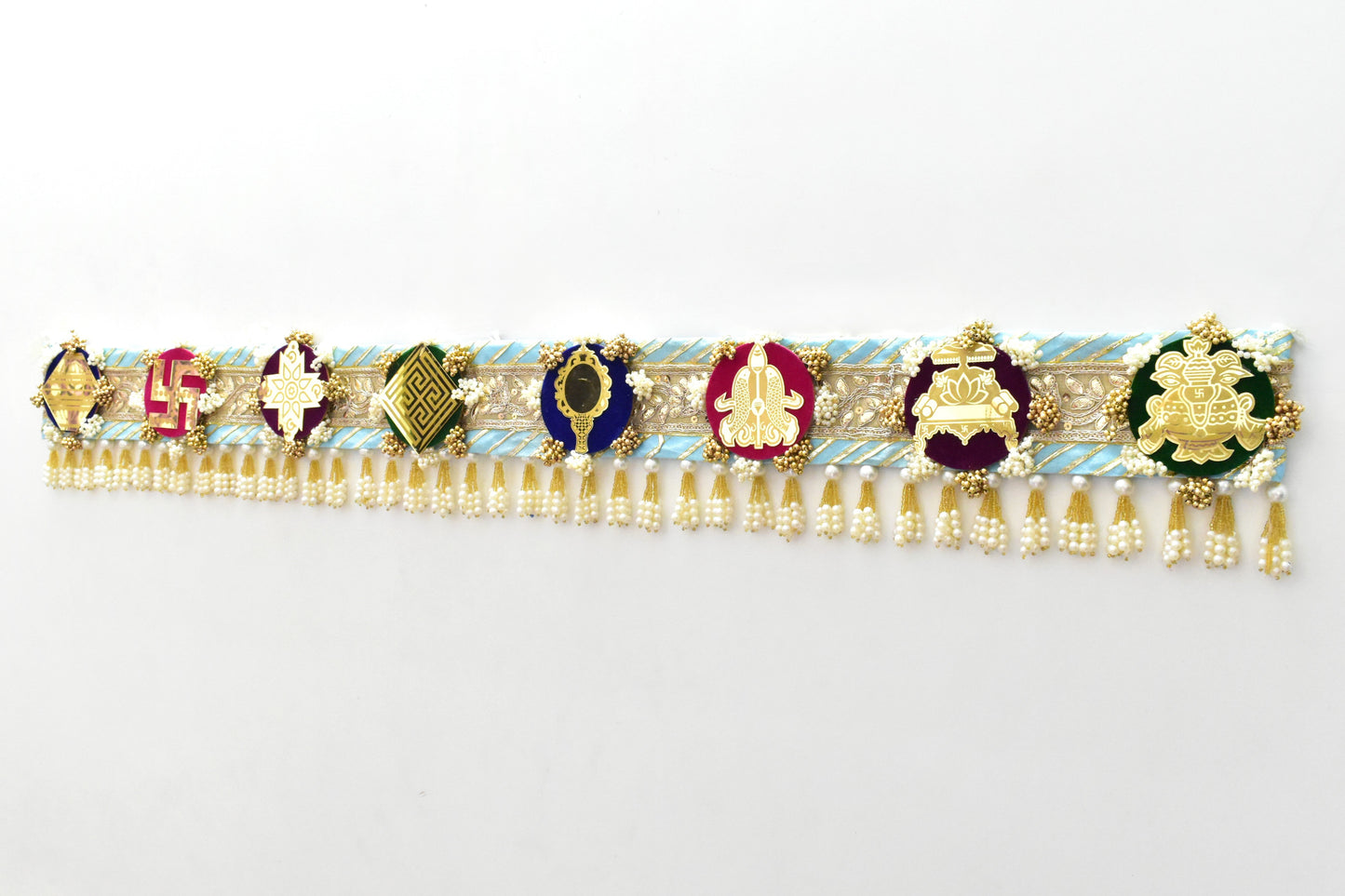 Decorative Toran door hanging above a doorway made with a theme of ashtamangal jain symbols