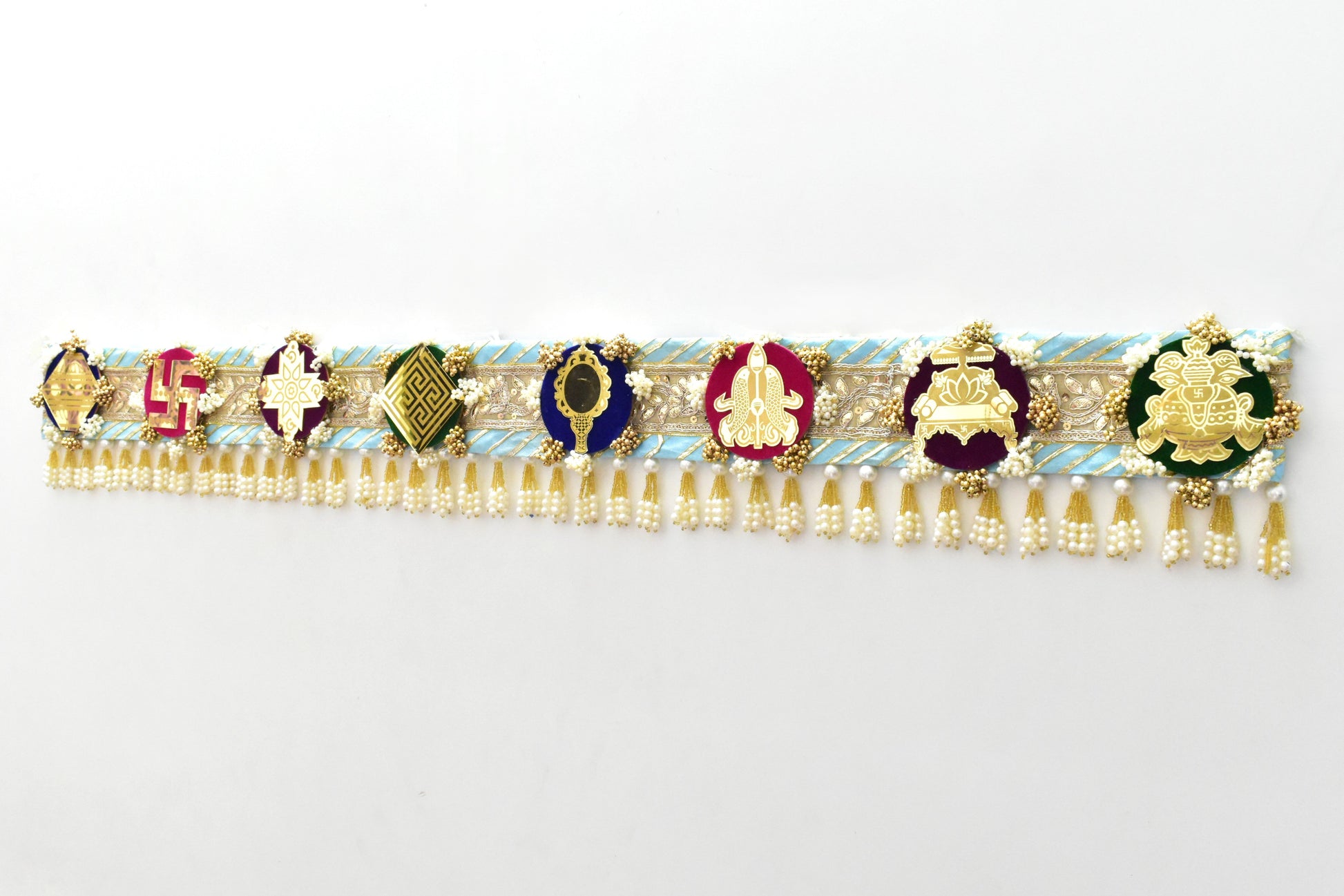 Decorative Toran door hanging above a doorway made with a theme of ashtamangal jain symbols