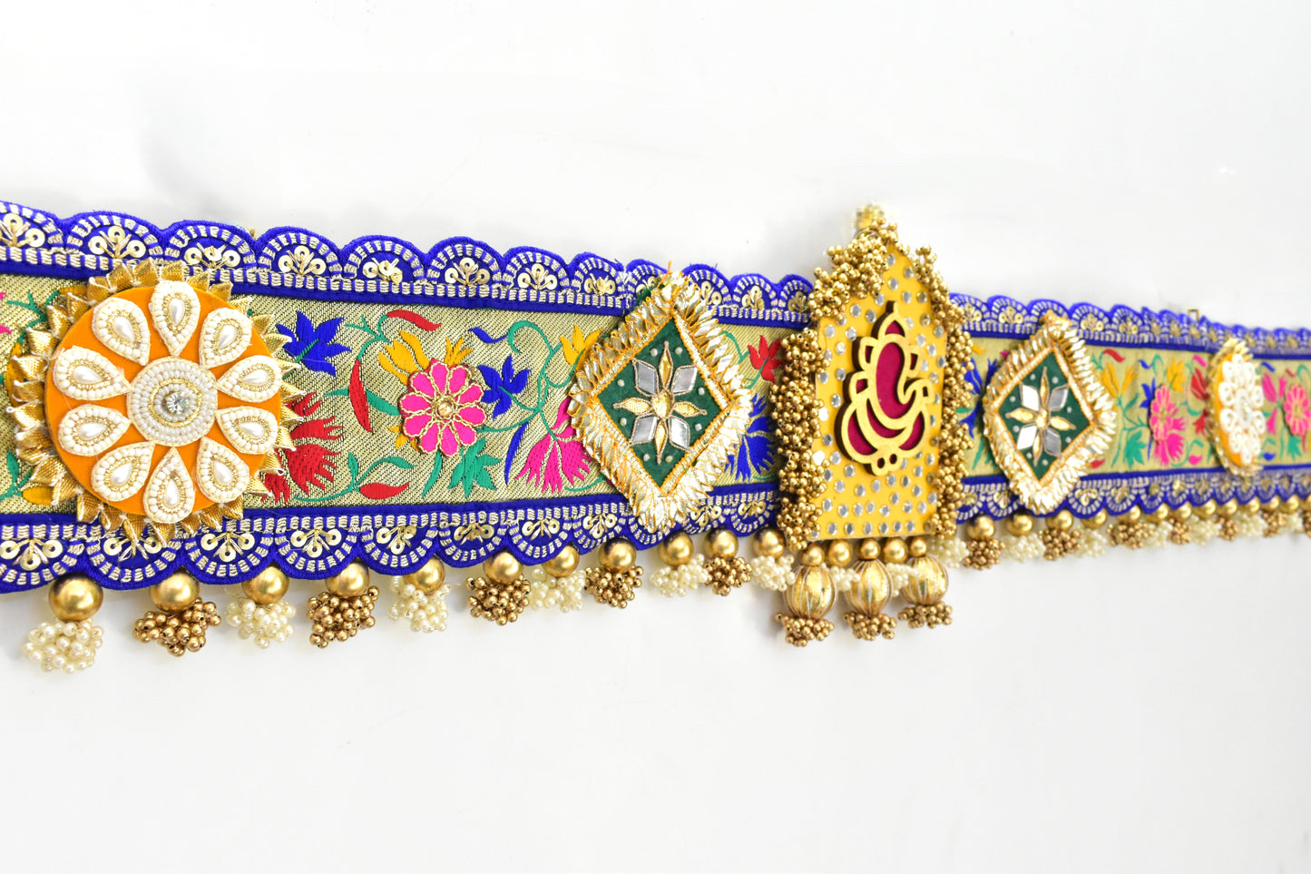 Decorative Ganesha Toran with colorful floral patterns and gold accents on a white background