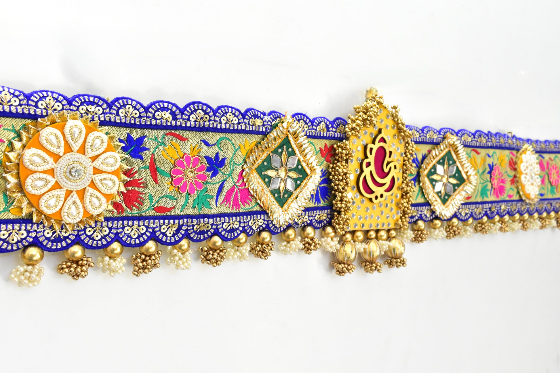 Decorative Ganesha Toran with colorful floral patterns and gold accents on a white background