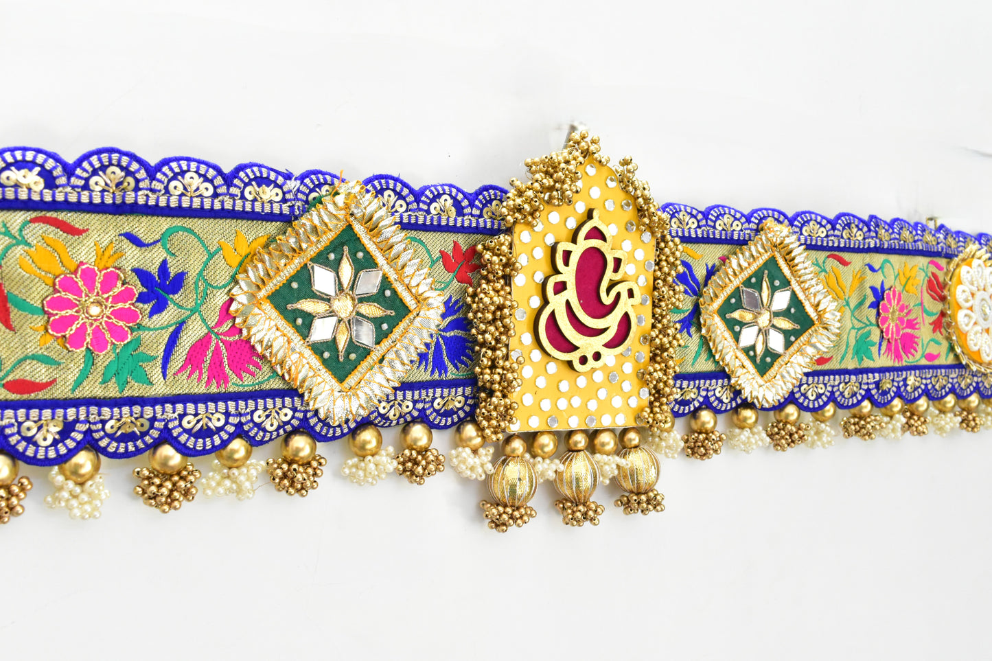 Decorative Ganesha Toran with colorful patterns and gold accents on a white background
