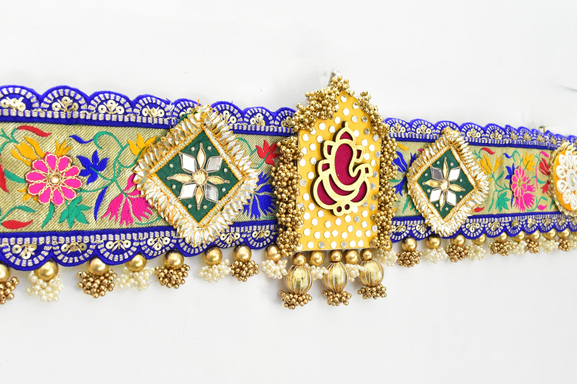 Decorative Ganesha Toran with colorful patterns and gold accents on a white background