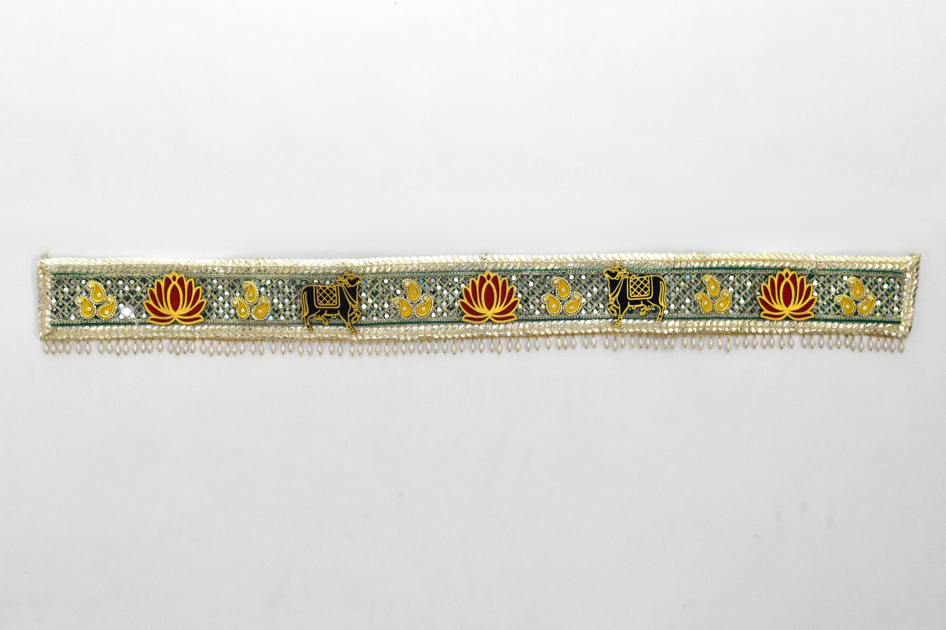 Decorative toran with cow and floral patterns on a white background