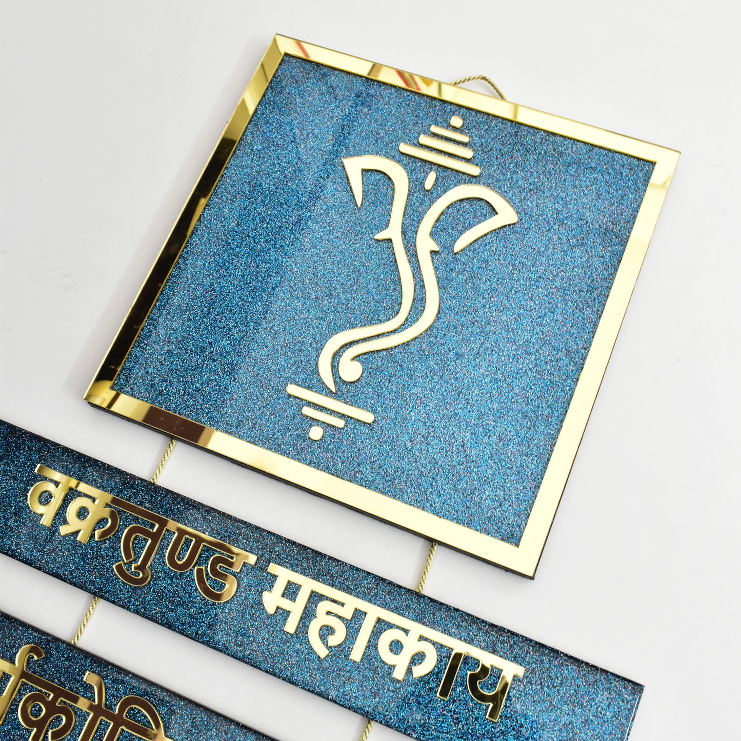Decorative items with Ganesha symbol and gold text on a blue background