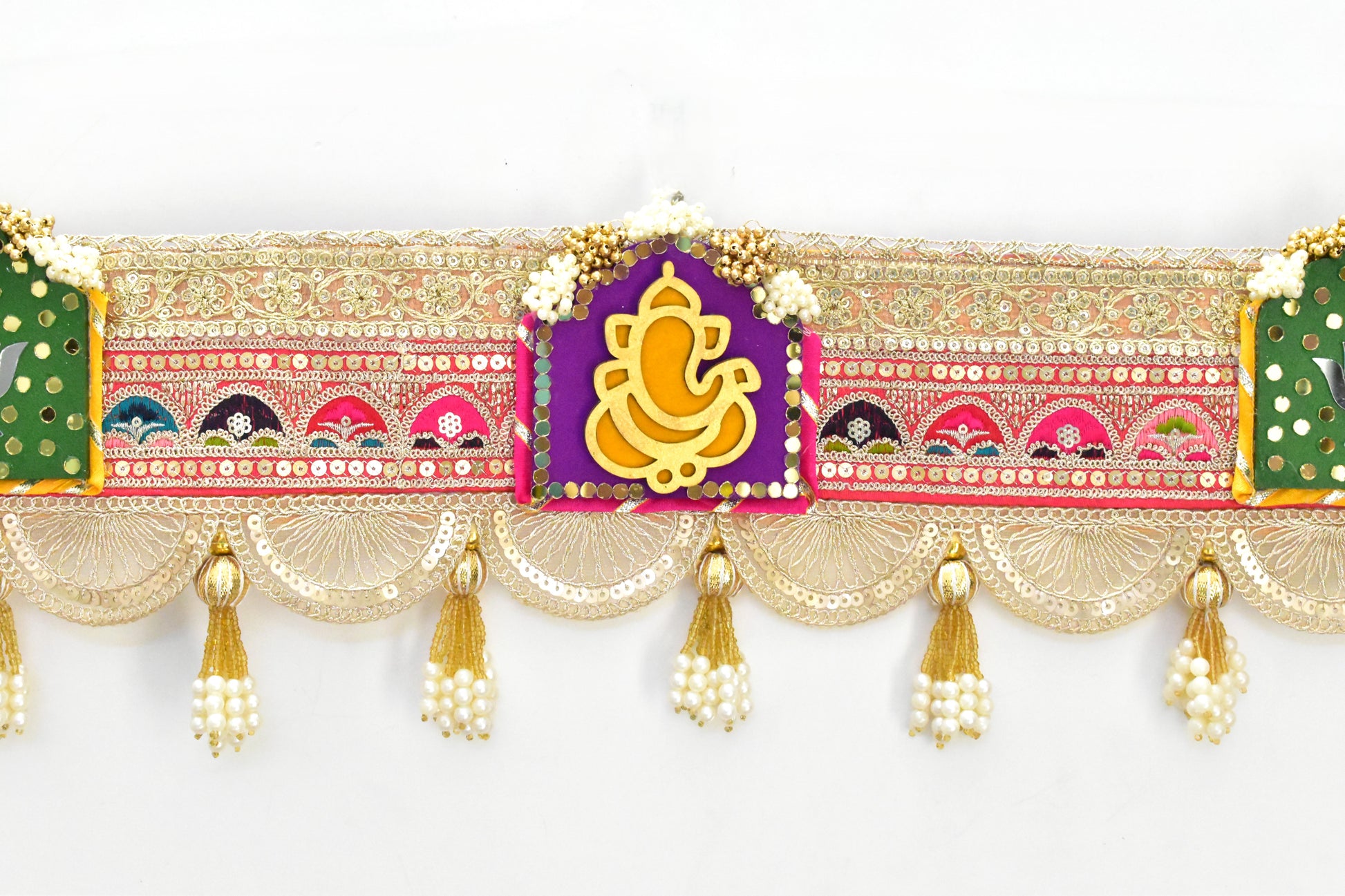 Decorative ganesha toran with colorful design and tassels on a white background