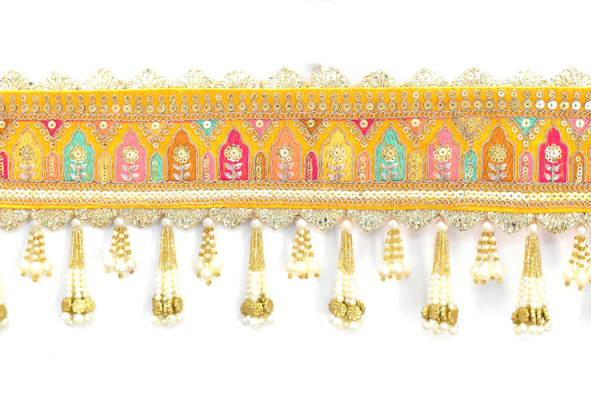 Decorative door toran hanging with colorful patterns and gold tassels on a white background