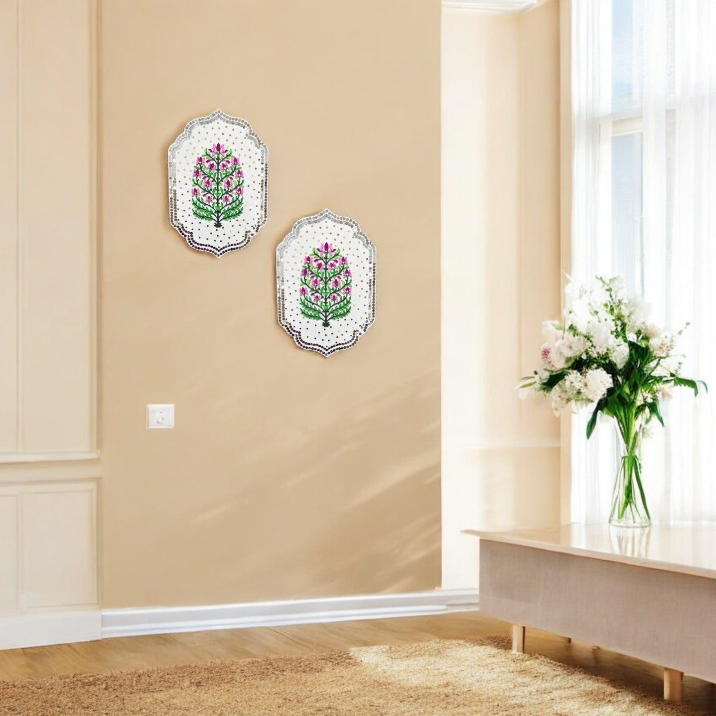 Two floral wall art pieces on a beige wall with a vase of flowers on a windowsill.