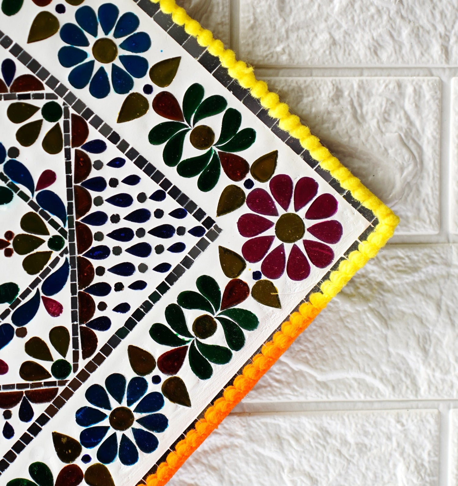 Decorative tile with floral pattern on a white tiled floor