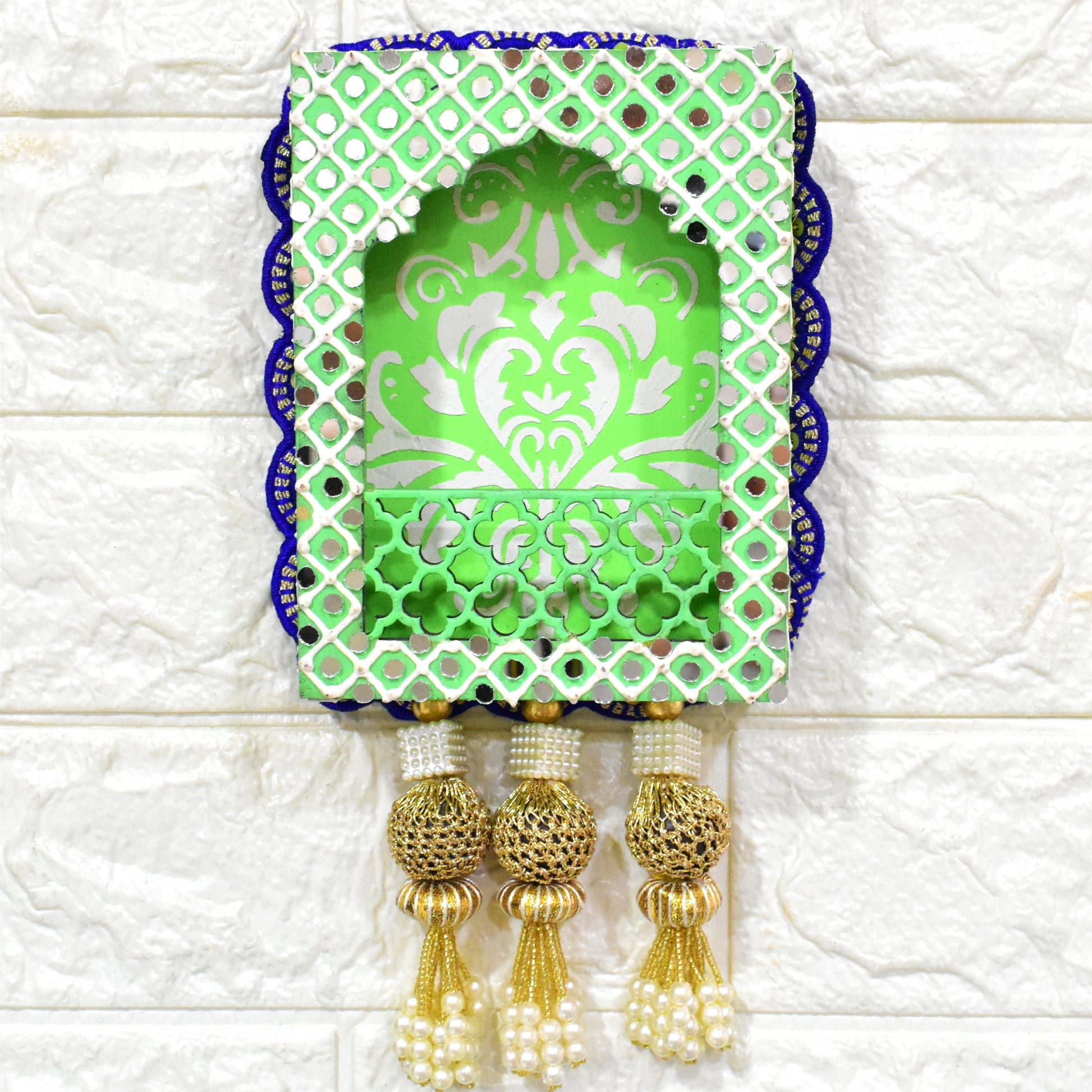 A handcrafted floral jharokha wall hanging with pearl tassels, featuring intricate floral cutwork and vibrant hand-painted patterns in green, and blue colors with golden accents.