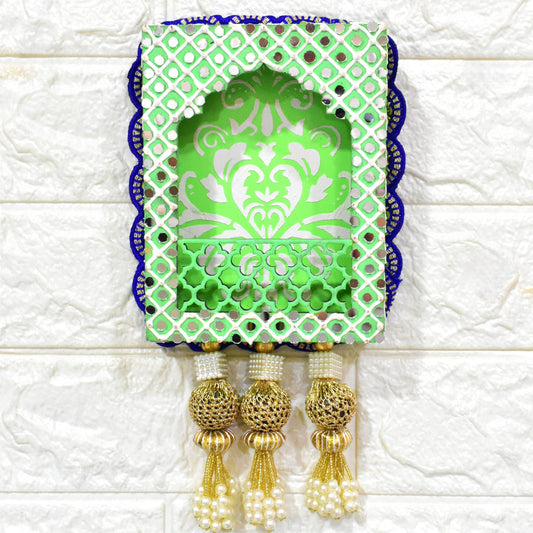 A handcrafted floral jharokha wall hanging with pearl tassels, featuring intricate floral cutwork and vibrant hand-painted patterns in green, and blue colors with golden accents.