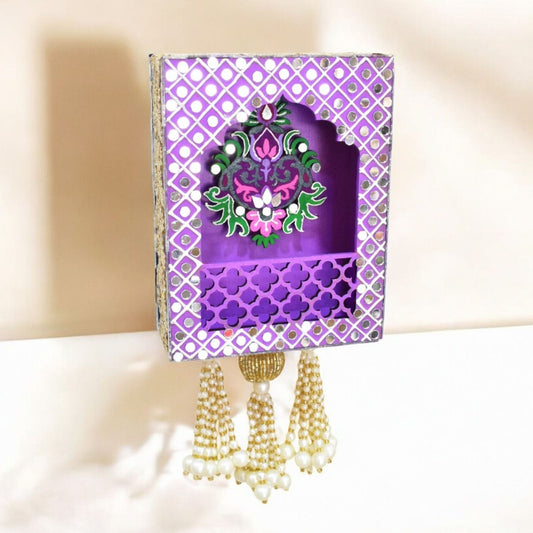 Decorative purple jharokha wall hanging with floral design and tassels on a light background