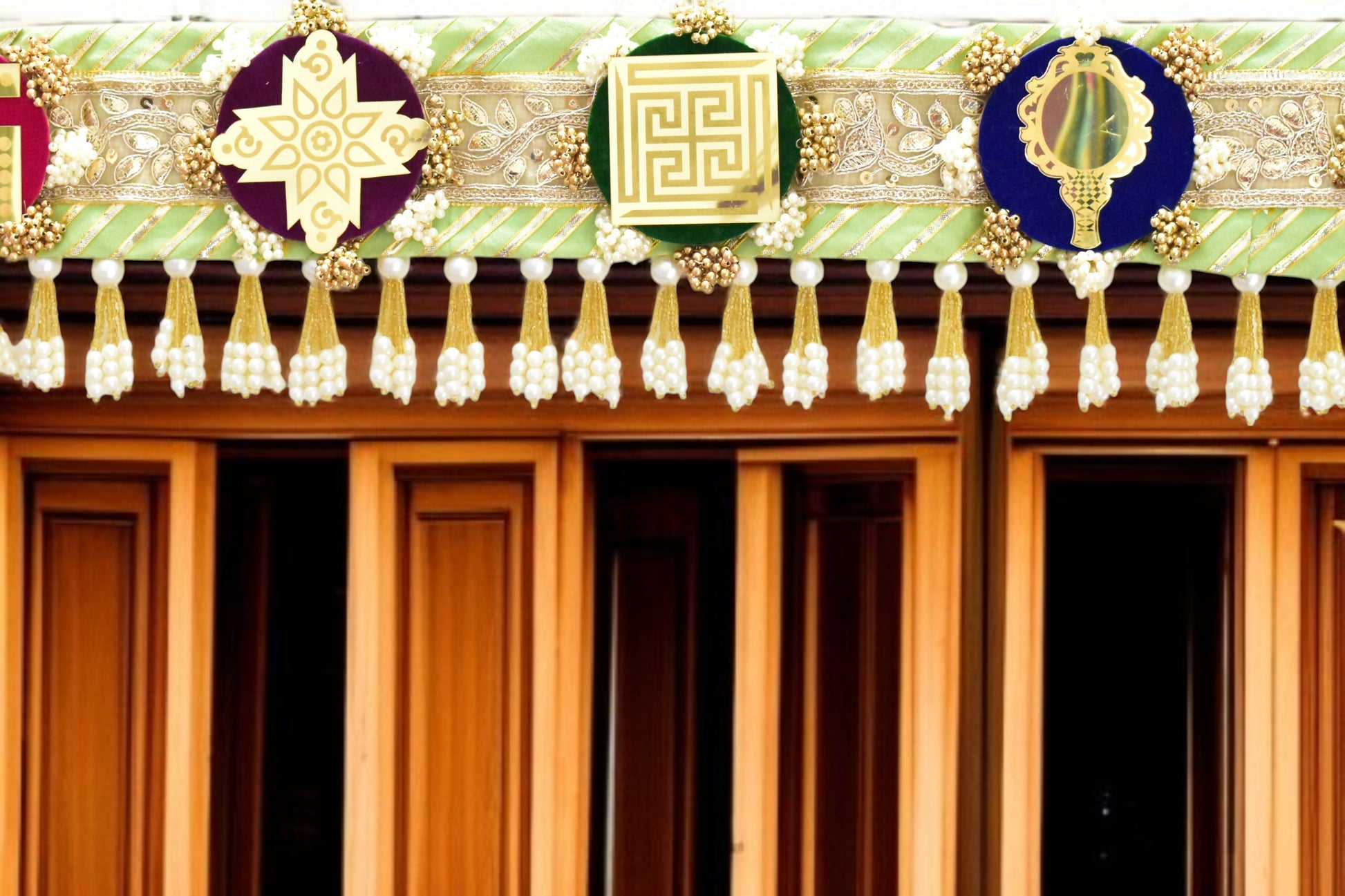 Green handcrafted Ashthamangala toran with traditional mirror work and 8 sacred symbols, ideal for ethnic home décor, door hanging, or pooja room decoration