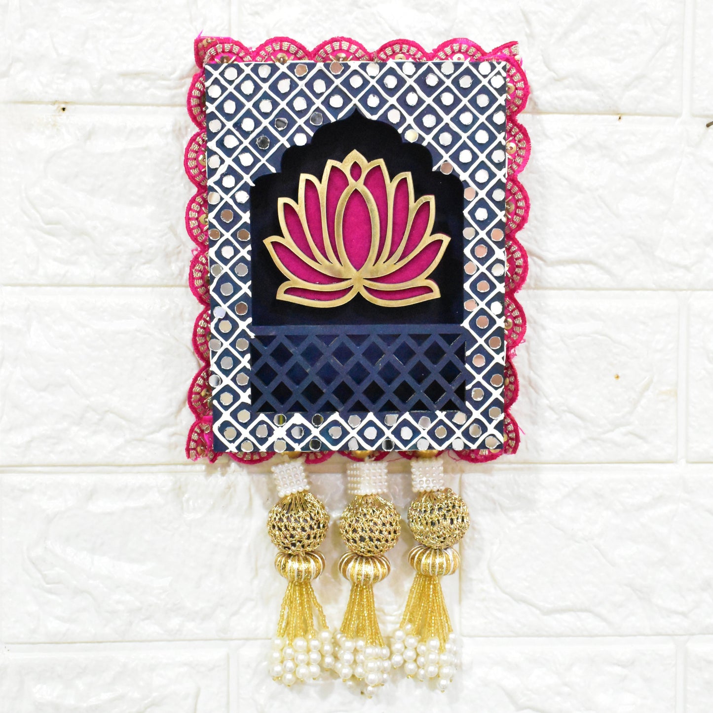 Pink Lotus Jharokha on a navy blue background with pearl and beads tassels on a white textured background.