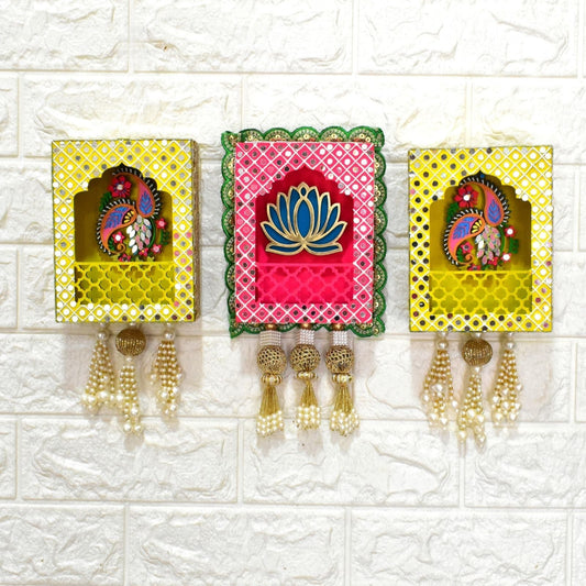 Three wall hangings of pink and yellow lotus and paisley design with decorative mirrors, beads and pearls tassels on a white background